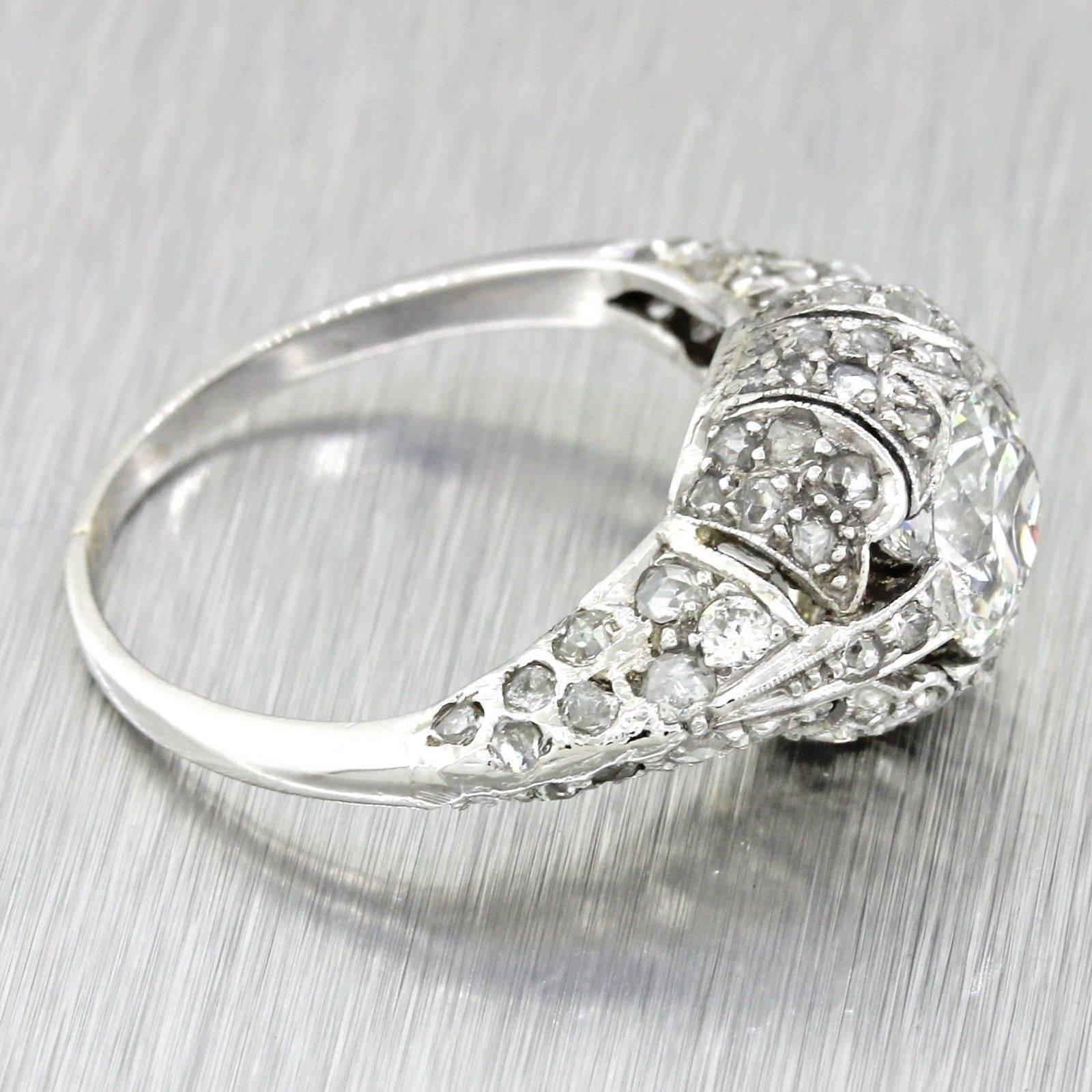 This is a beautiful antique Art Deco Platinum solitaire with side accents diamond engagement ring that can be dated back to the 1920s. This ring's center diamond graded by GIA; one of worlds most reputable diamond grading organizations.The ring is a