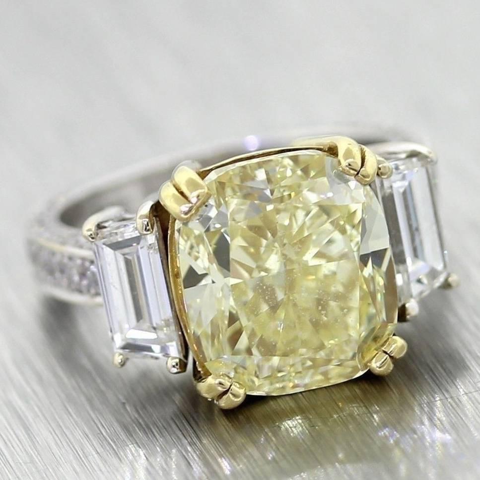 This is another gorgeous engagement ring crafted of solid 18k white gold with the center stone set in an 18k yellow gold head. The ring contains a 7.2ct fancy yellow cushion cut diamond and is flanked by 2 main accent diamonds (one on either side)