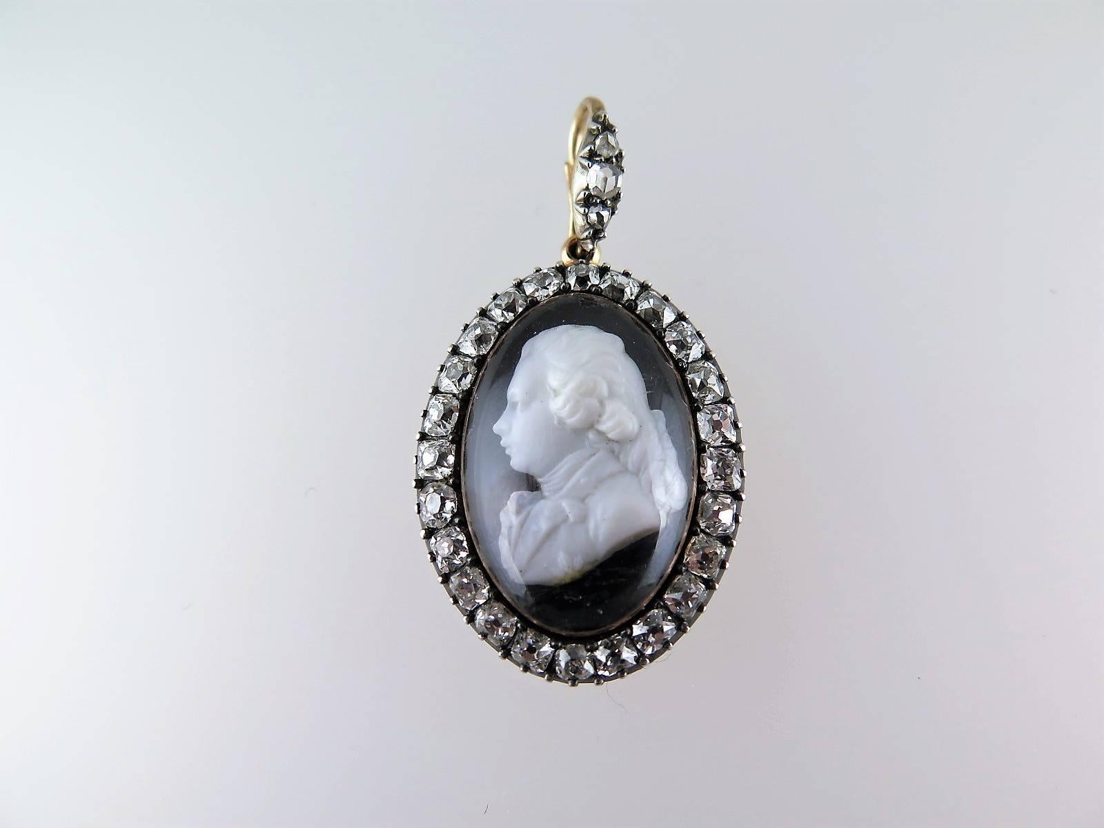 The oval pendant set with a paste cameo depicting the young George IV as Prince of Wales within a surround of old mine-cut diamonds with a diamond set bail, mounted in silver and gold, inscribed 'For George Ormsby-Gore from his grandfather G.F.