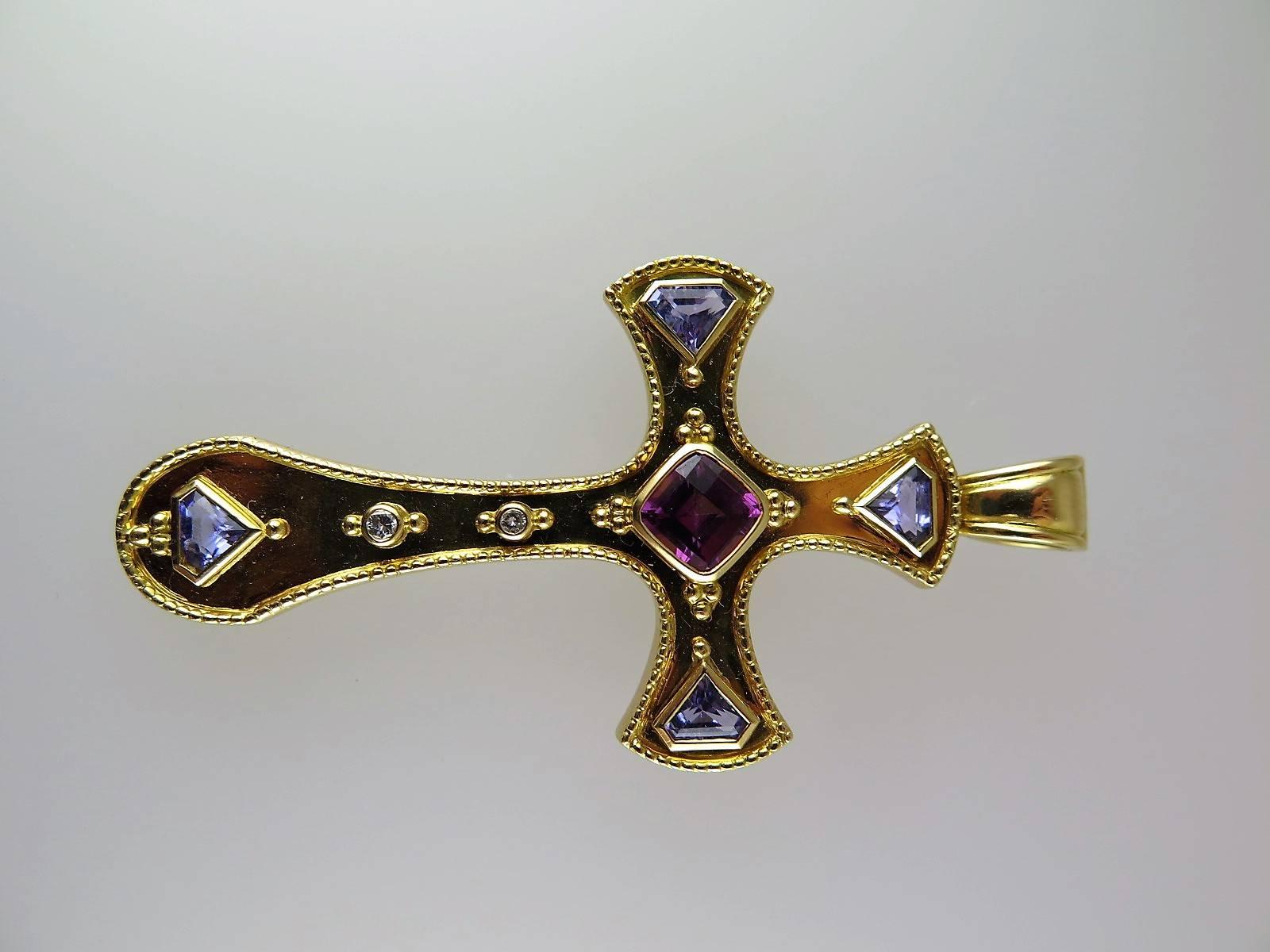The Gothic cross set to the centre with a cushion-shaped pink sapphire and four wedge-shaped sapphires to the cardinal points, further small diamond detail, British hallmarks for London, 1992