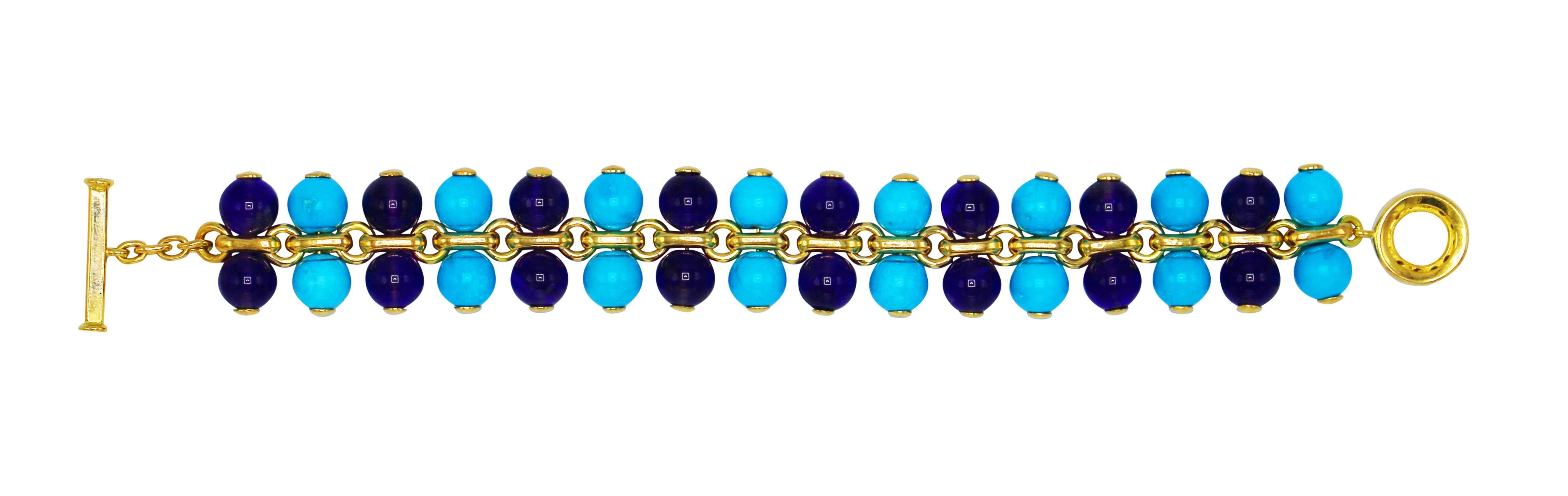 An original design by Rosaria Varra, the highly flexible bracelet composed of yellow gold links flanked on each side by numerous turquoise and amethyst beads measuring approximately 8.0 mm., completed by a circular clasp set with round diamonds