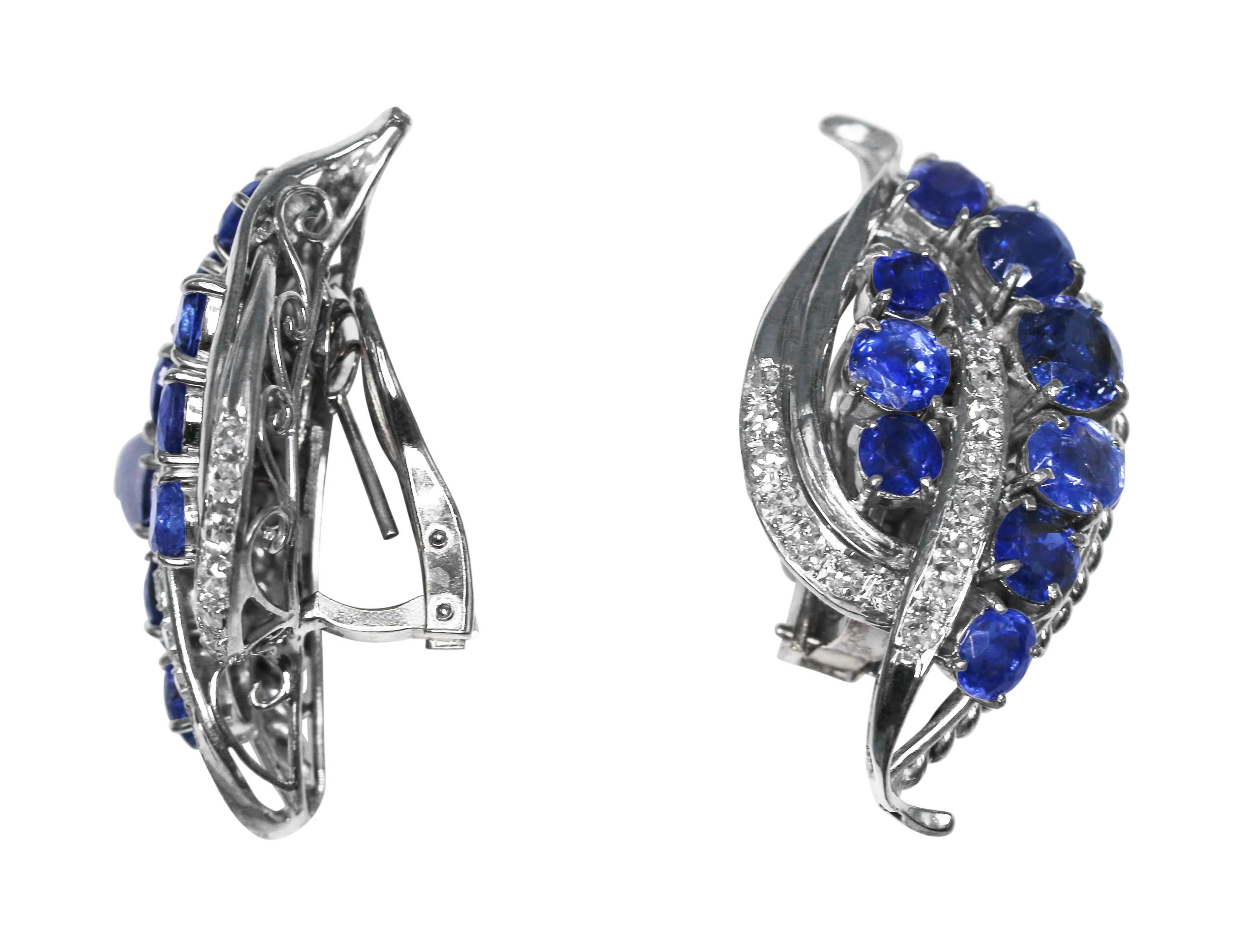 Lovely pair of sapphire and diamond earclips, circa 1950, designed as stylized leaves set with unheated sapphires weighing approximately 12.75 carats, accented by round diamonds weighing approximately 0.75 carat, mounted in 18 karat and 14 karat