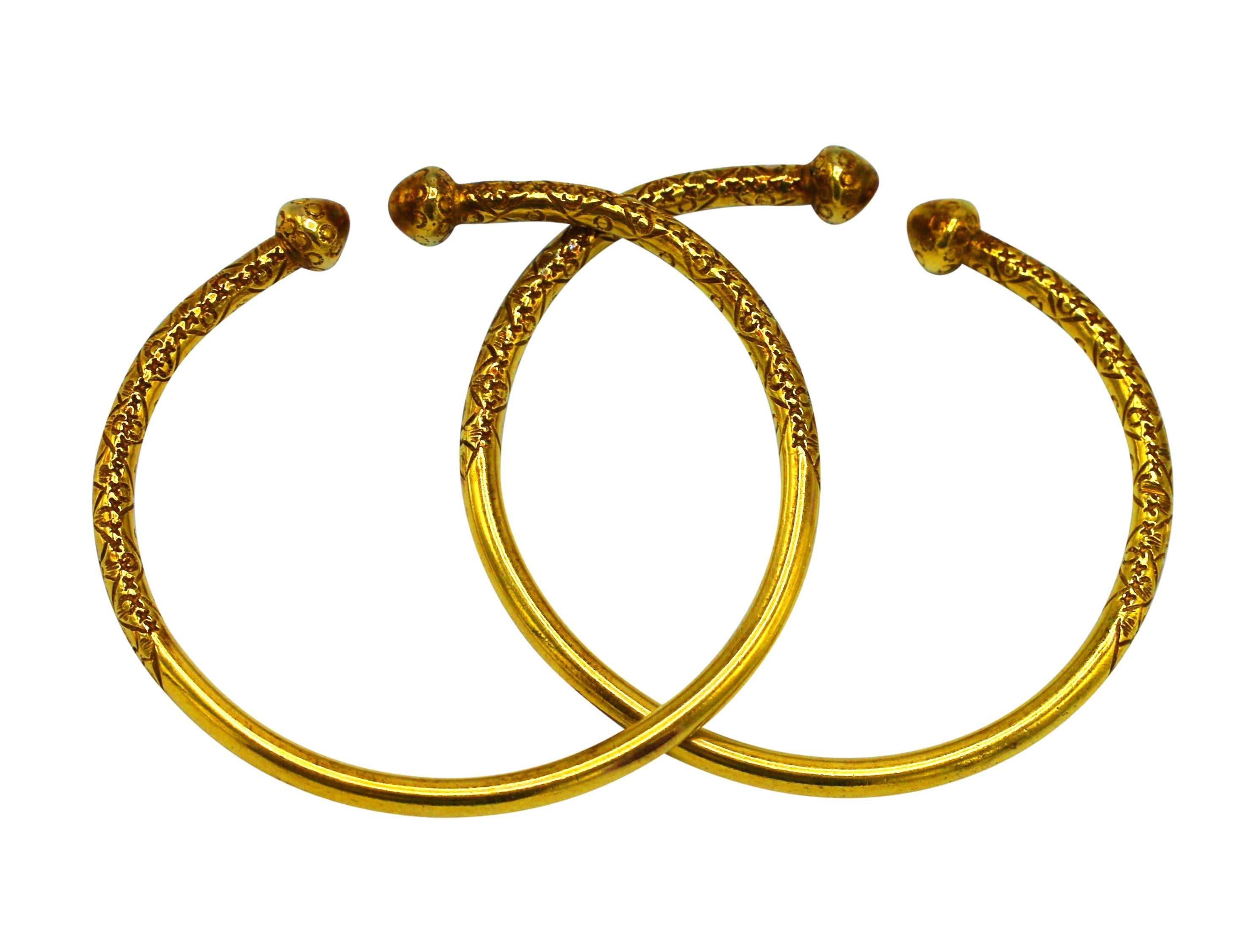 The 18 karat yellow gold bangles with carved ornate patterns, gross weight 58.4 grams, length 7 inches, width 1/4 inch, beautiful on the wrist to wear together or stacked with several other bracelets.