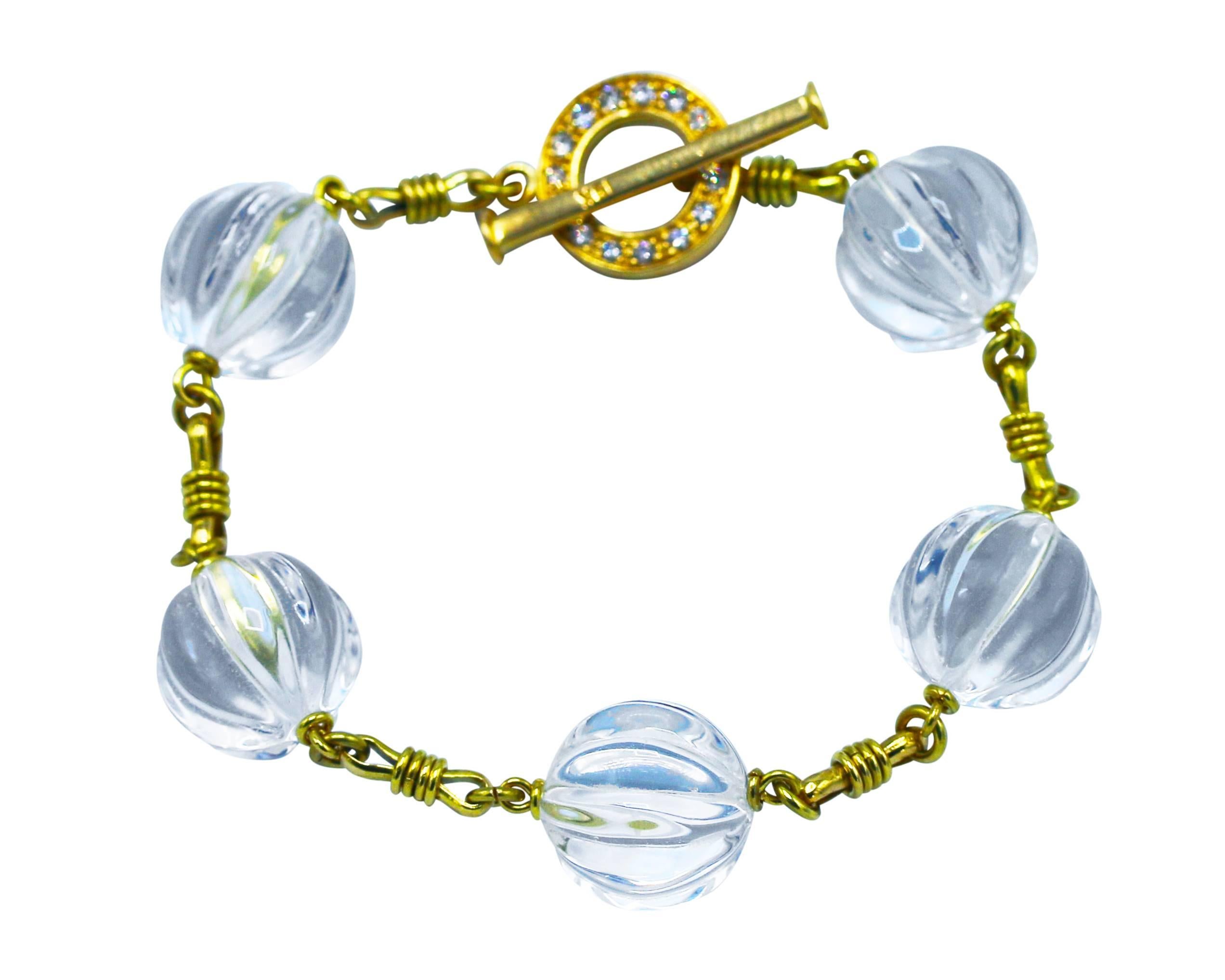 Wonderful handmade rock crystal, diamond and 18 karat gold bracelet, composed of a series of carved rock crystal beads, alternating with hand-twisted gold links, completed by a circular clasp set with round diamonds weighing approximately 0.40