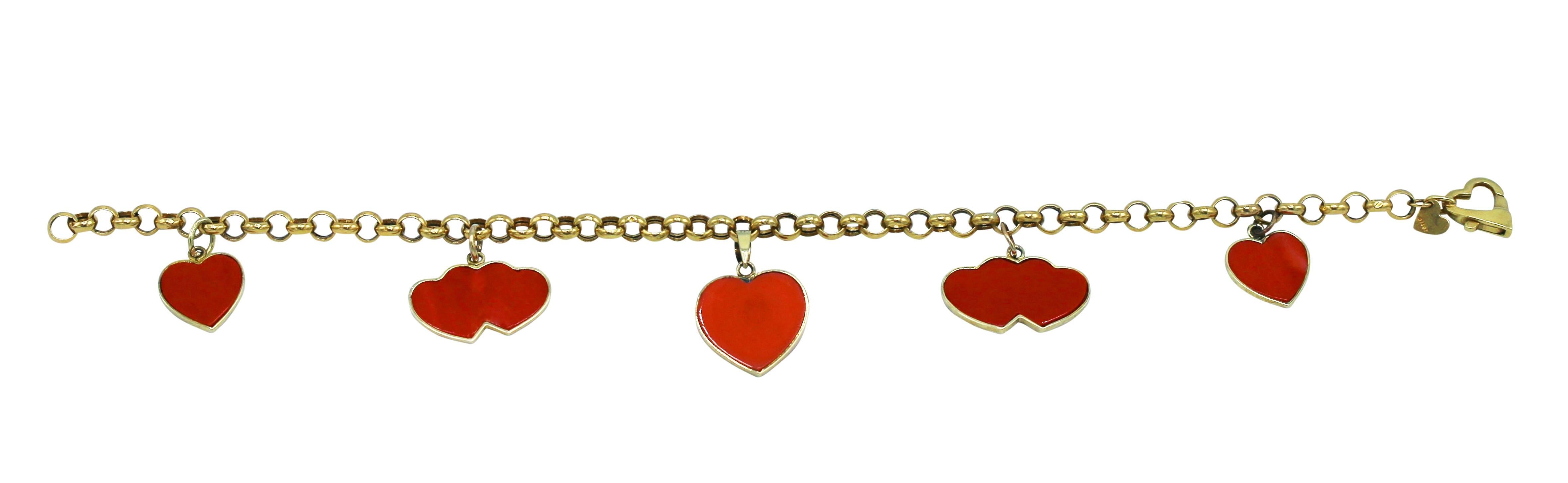 18 karat yellow gold and red coral charm bracelet, circa 1960, set with alternating charms of single heart and double heart charms, the clasp of heart-shape, gross weight 9.6 grams, length 9 inches, width 3/4 inch, an endearing gift  for a special