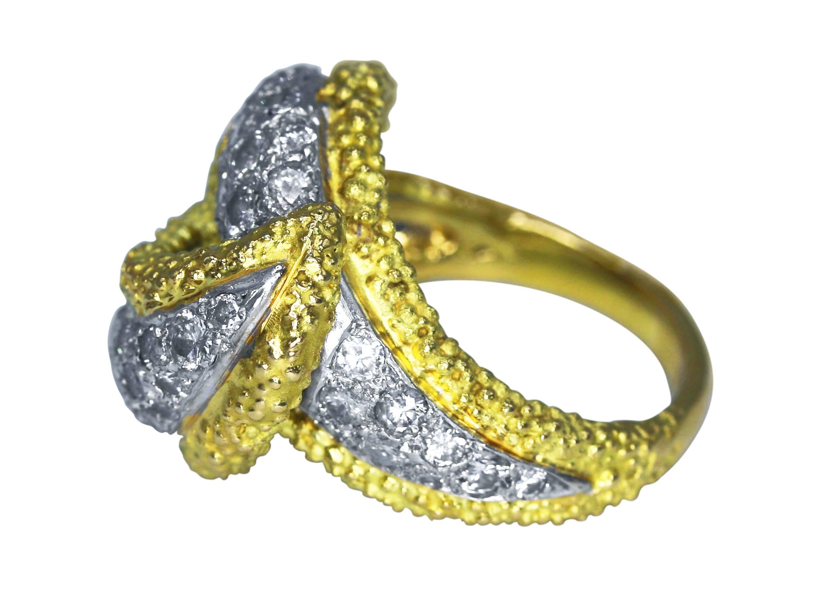 18 karat white and yellow gold and diamond ring, circa 1970, of cross over design with white gold center set with round diamonds weighing approximately 2.60 carats, within textured yellow gold borders, size 5 1/2, gross weight 12.4 grams, measuring