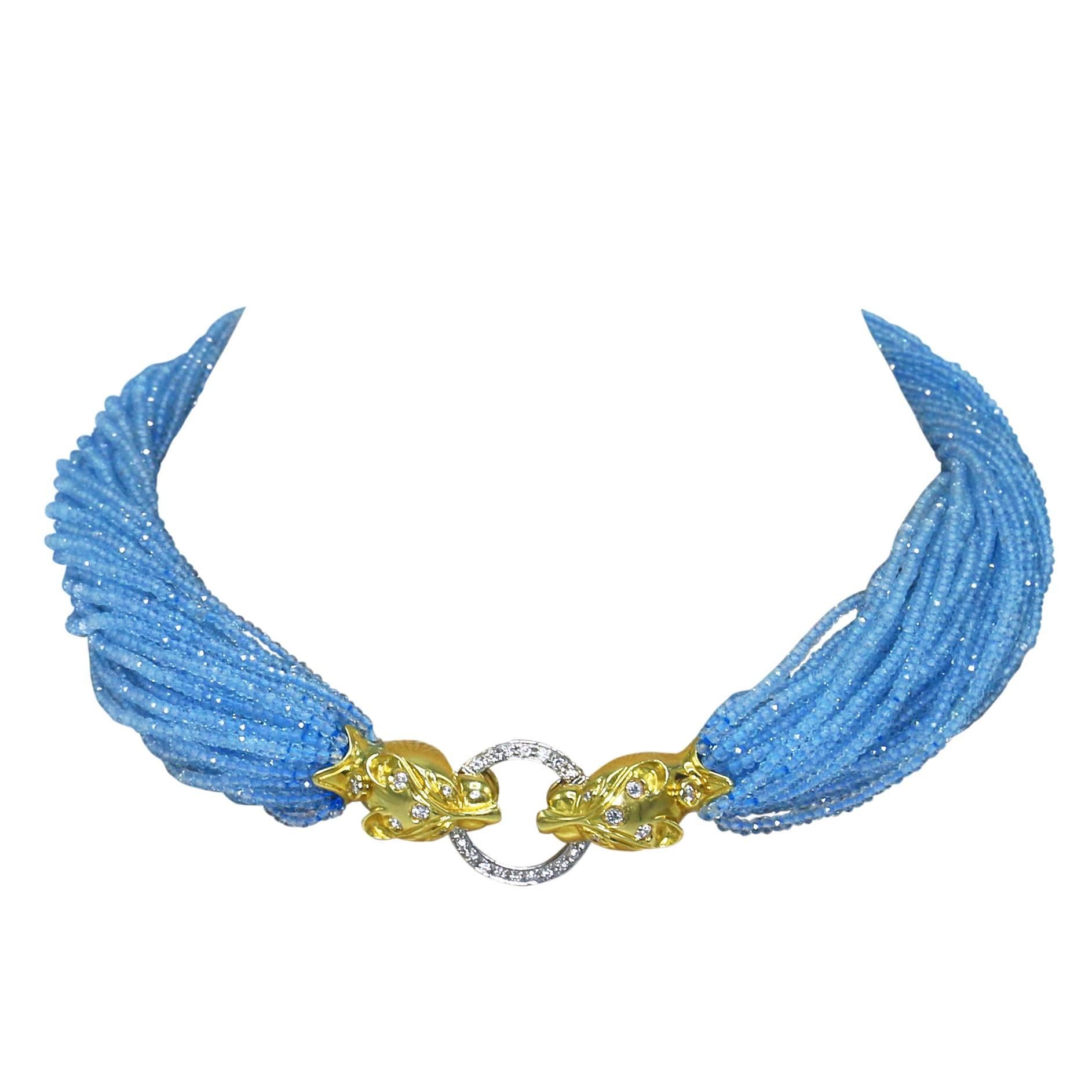 18 karat yellow gold, diamond and blue topaz bead torsade necklace, designed as multiple strands of blue topaz beads, connected at the center by two panther heads supporting a ring in their mouths, set throughout with round diamonds weighing