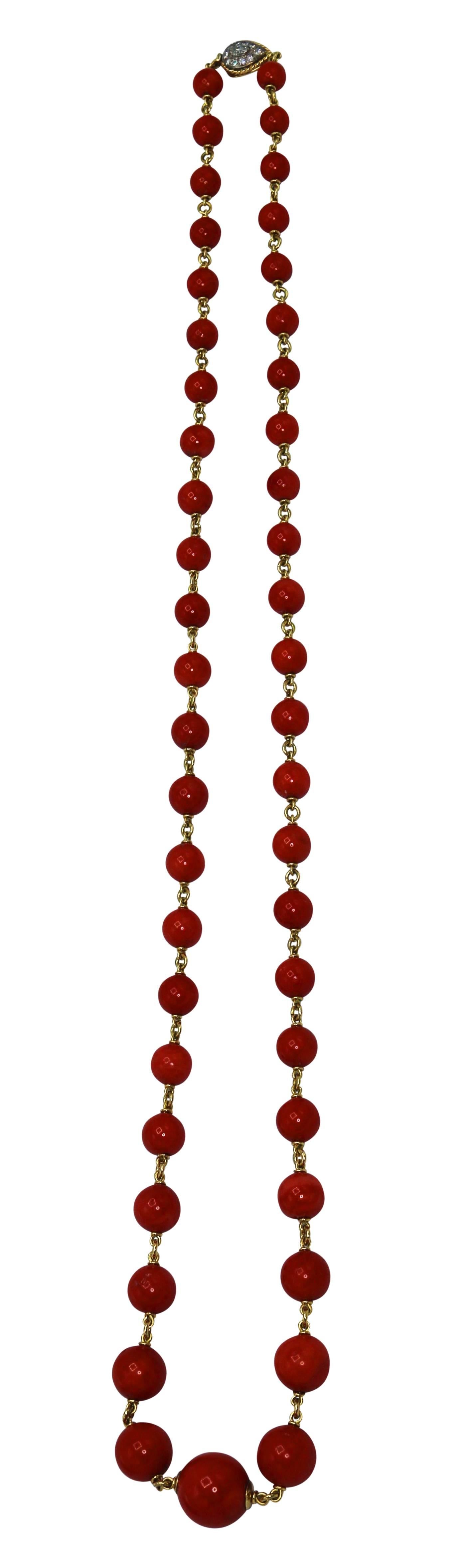 The graduated long chain necklace composed of numerous coral beads of rich red hue measuring 9.5 to 17.8 mm., spaced by gold links, completed by a pear-shaped clasp set with small round diamonds weighing approximately 0.80 carat, gross weight 112.0