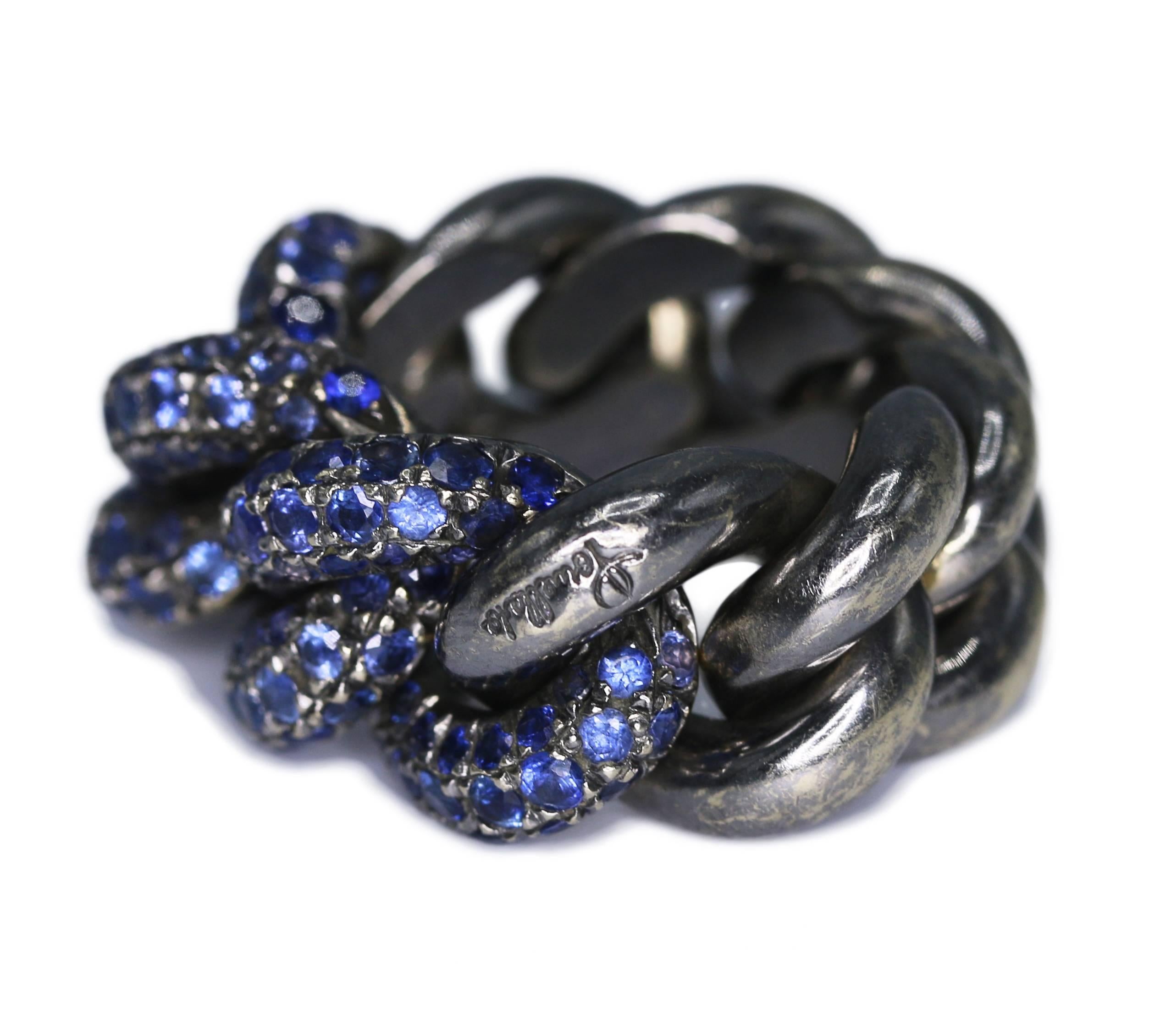 18 karat blackened gold and sapphire ring by Pomellato, designed as an interlocking chain of blackened gold, set at the front with round sapphires, gross weight 24.4 grams, size 6, measuring 1 by 1 by 1/2 inch, signed Pomellato. This ring is quite