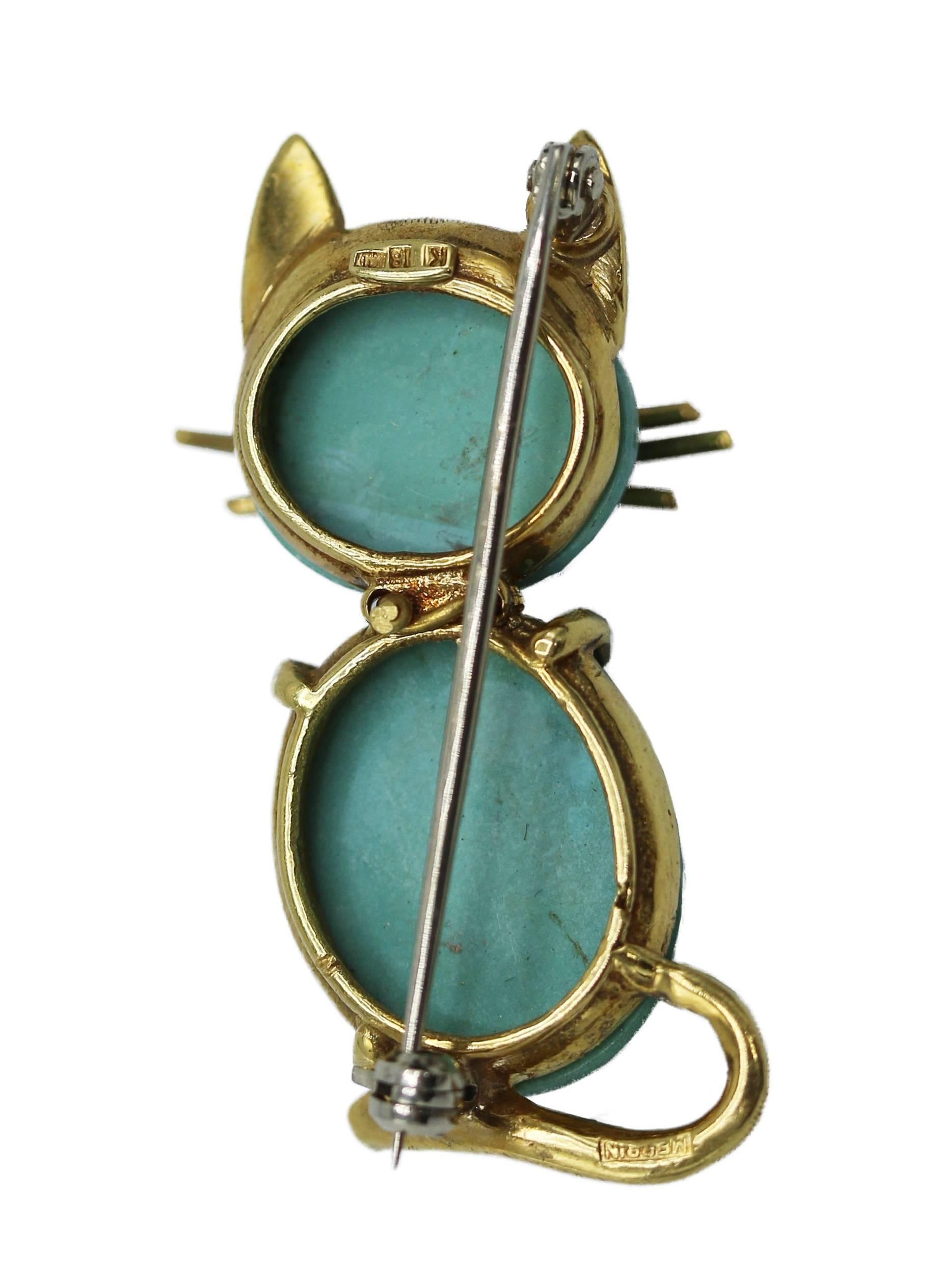 18 karat yellow gold, turquoise and ruby cat brooch, circa 1960, designed as a seated cat composed of 2 turquoise cabochons and eyes set with round rubies, the whiskers, ears and tail of textured gold, gross weight 11.7 grams, measuring 1 1/2 by 3/4
