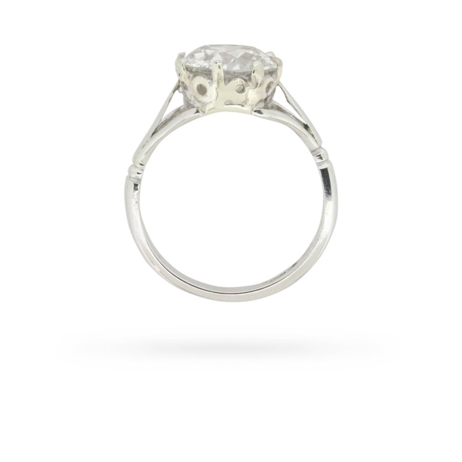 This stately 1920s diamond solitaire engagement ring was handmade in platinum, elegantly presenting a striking 2.30 carat old cut diamond in a period setting featuring a lovely pierced openwork gallery and tri-split shoulders. An heirloom in the
