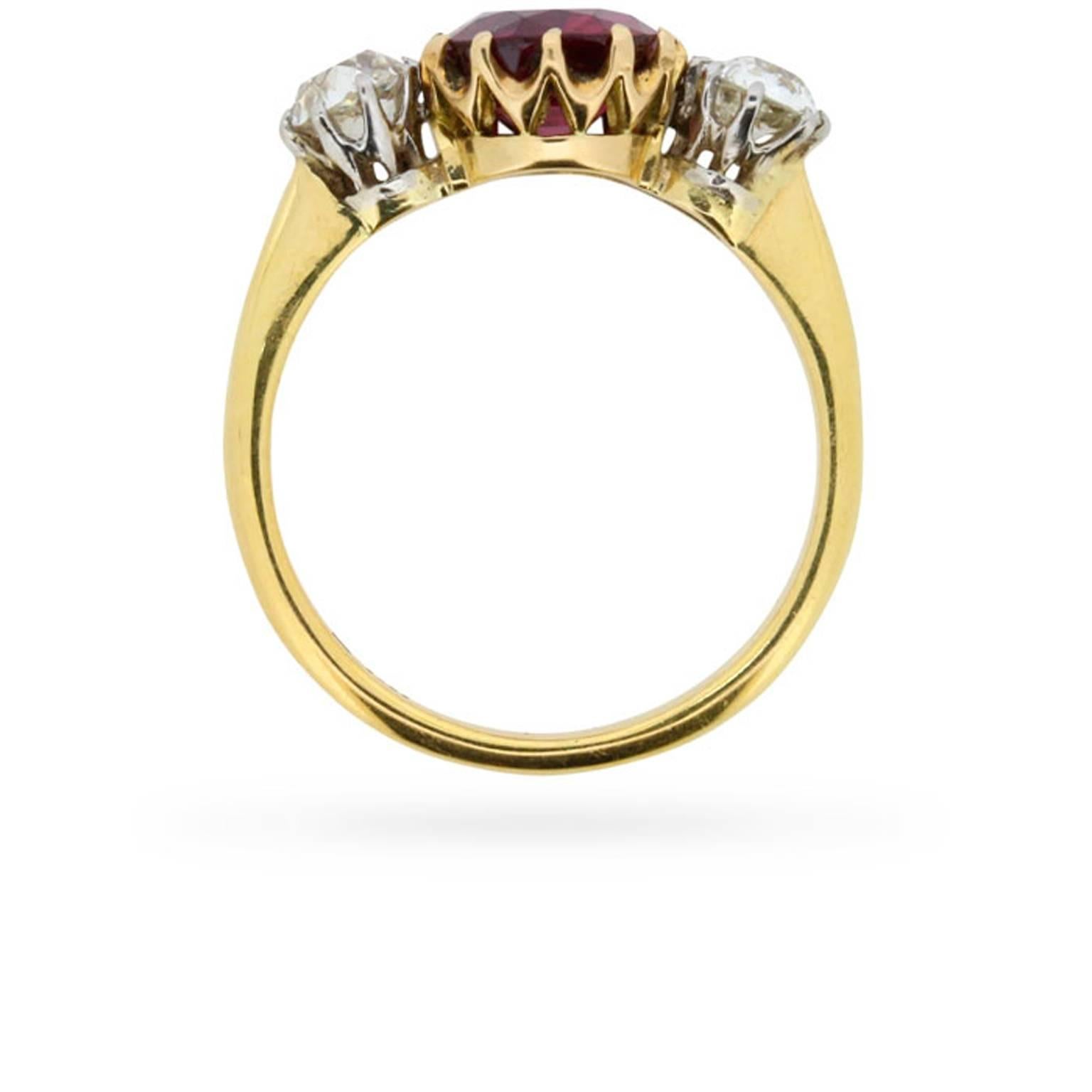 Between a pair of 0.35 carat old cut diamonds, this Victorian era three stone ring centres a 1.90 carat, oval-shaped, natural transparent red ruby, which has been independently certified by the Gem & Pearl Laboratory. The diamonds are H in colour,