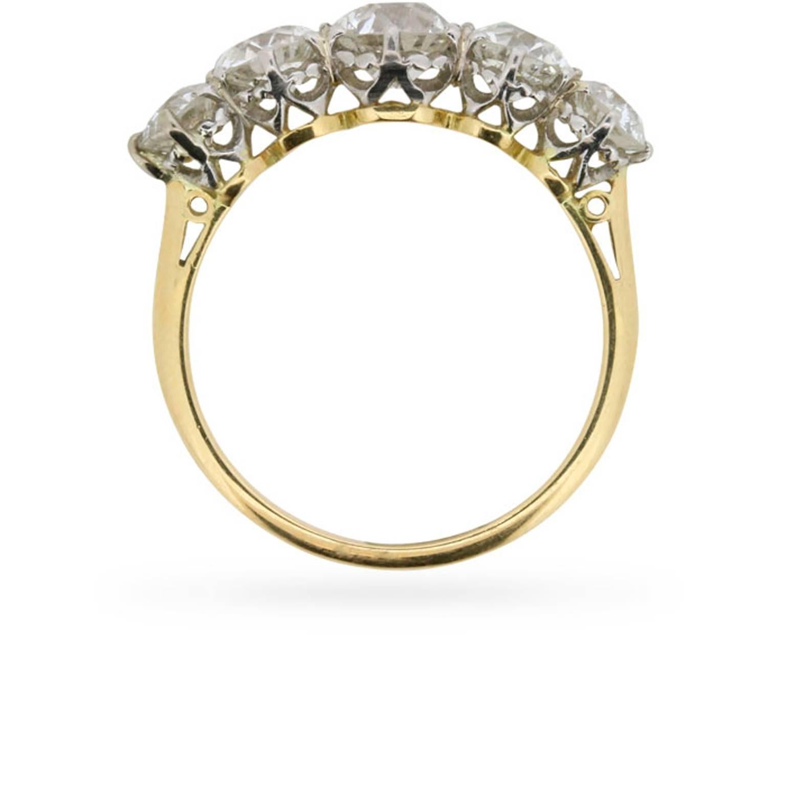 Originating in the 1910s, a gorgeous 2.20 carats of old cut diamonds are set shoulder to shoulder to comprise the heart of this antique diamond ring.

This ring was designed in perfect balance with a 0.70 carat diamond at its centre, and a 0.45