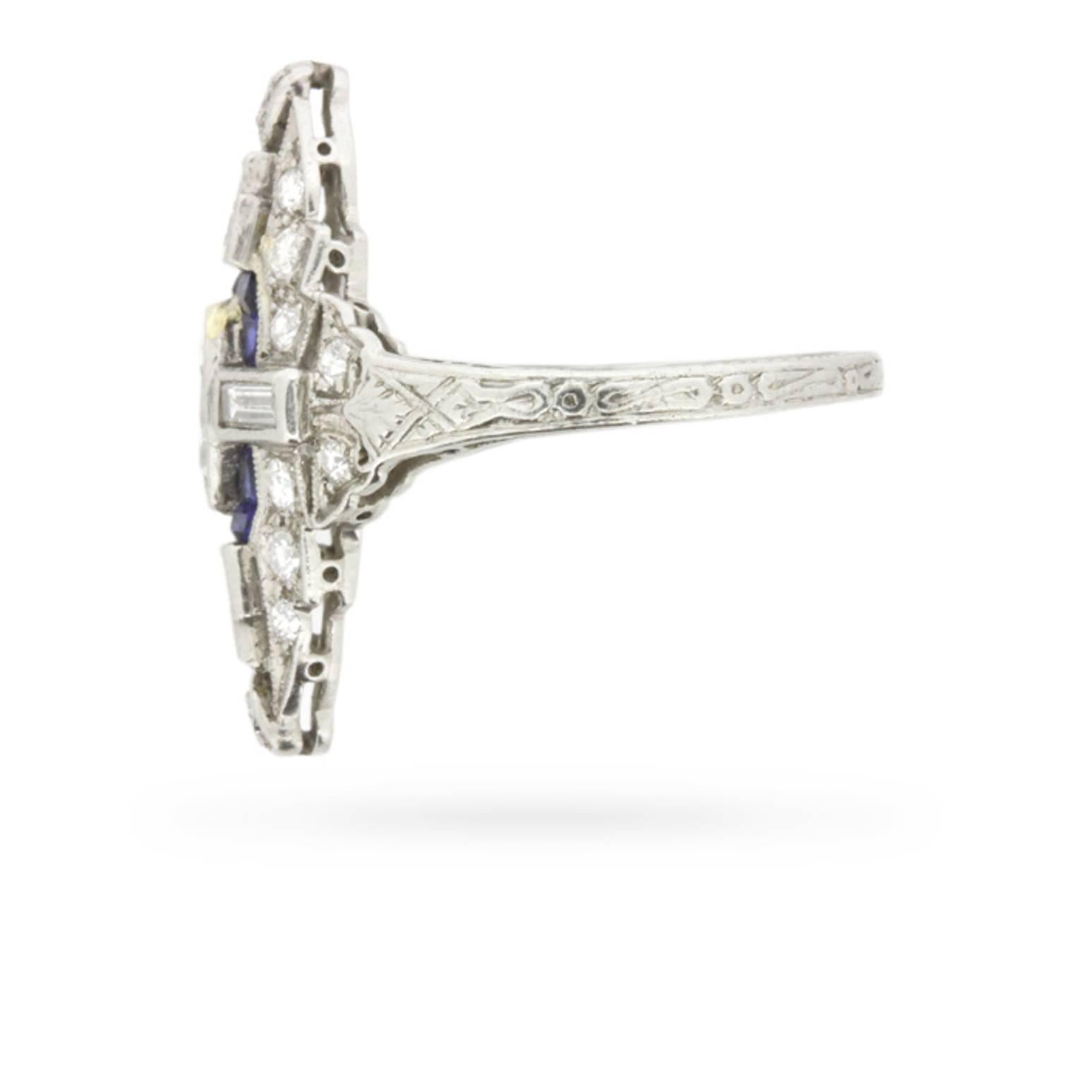 An exquisite Art Deco dinner ring in the era’s most preferred combination of diamonds and sapphires!

Handmade in platinum at the height of the Jazz Age, this sophisticated ring centres one marquise cut diamond within in a pool of sapphires, inside
