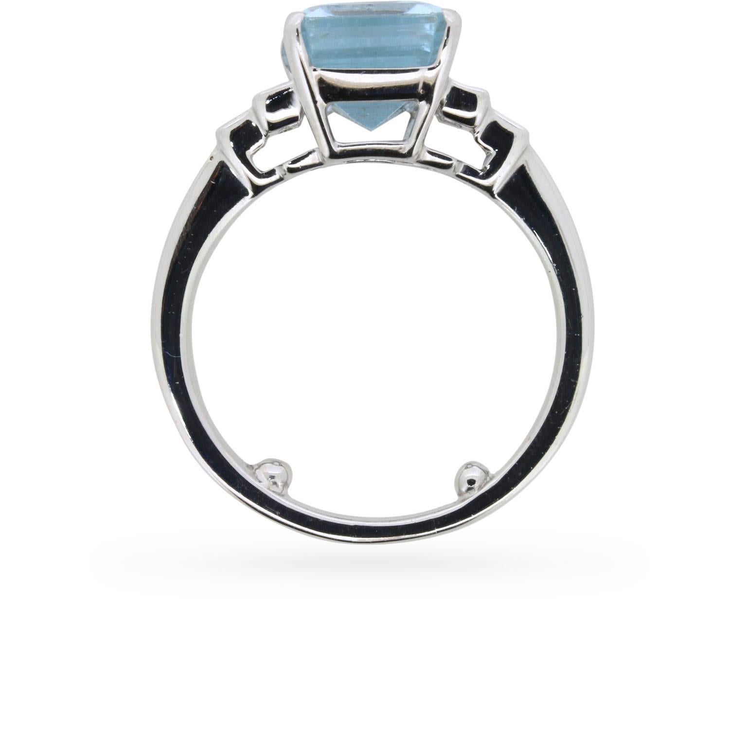 Dieser fabelhafte Vintage-Ring aus den 1960er Jahren mit starkem Art-déco-Einfluss trägt einen Aquamarin mit 4,35 Karat im Smaragdschliff zwischen gestuften Schultern.

Der Ring ist in 18 Karat Weißgold gefasst. Die Schultern des Rings sind