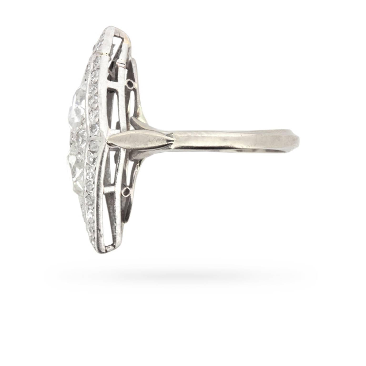 An old cut diamond set at each cardinal point complements two pear-shaped diamonds totalling 1.30 carats, which have been set end to end, forming a marquise shape at the centre of this Edwardian era dinner ring.

A delicate border of old cut