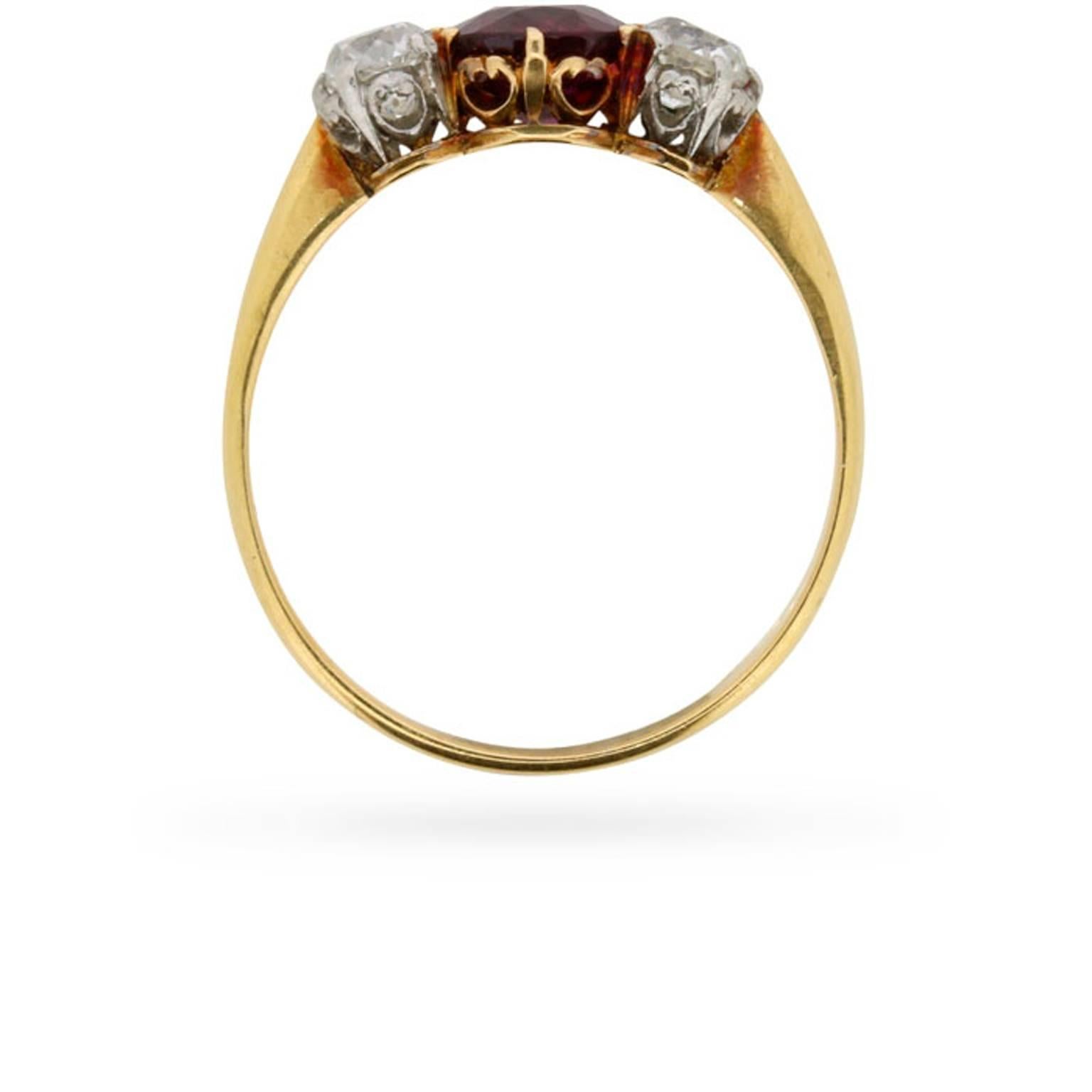 A vibrant 1.01 carat old cut ruby is joined on either side by a 0.25 carat old cut diamond at the centre of this late Victorian/early Edwardian era three stone ring.

This sumptous antique ruby is claw set in 18 carat yellow gold and the diamonds