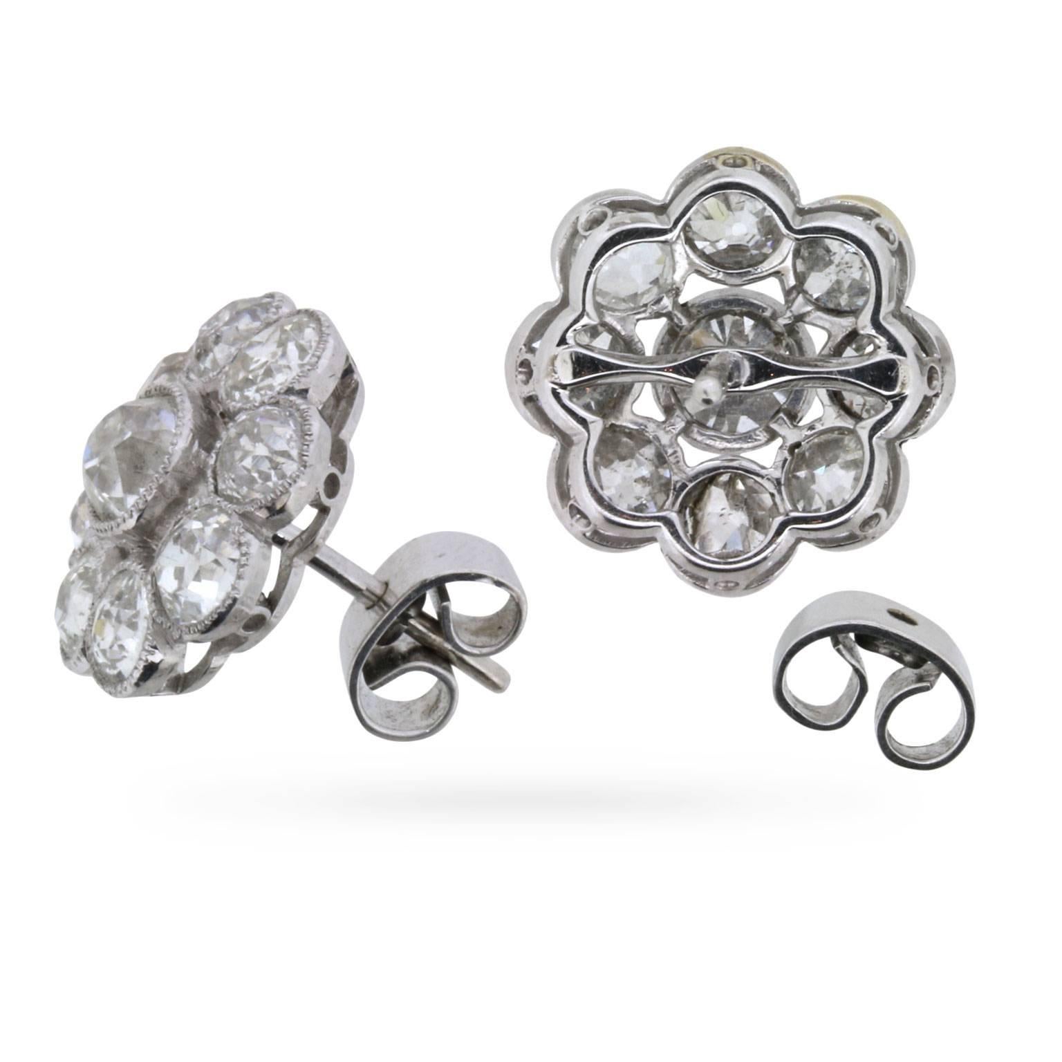 Dating back to the 1930s, these fabulous diamond cluster earrings feature a matching pair of old cut diamonds, each encircled by a glittering ensemble of eight complementary old cuts, all rubover-set in millegrain-edged platinum.

With a total