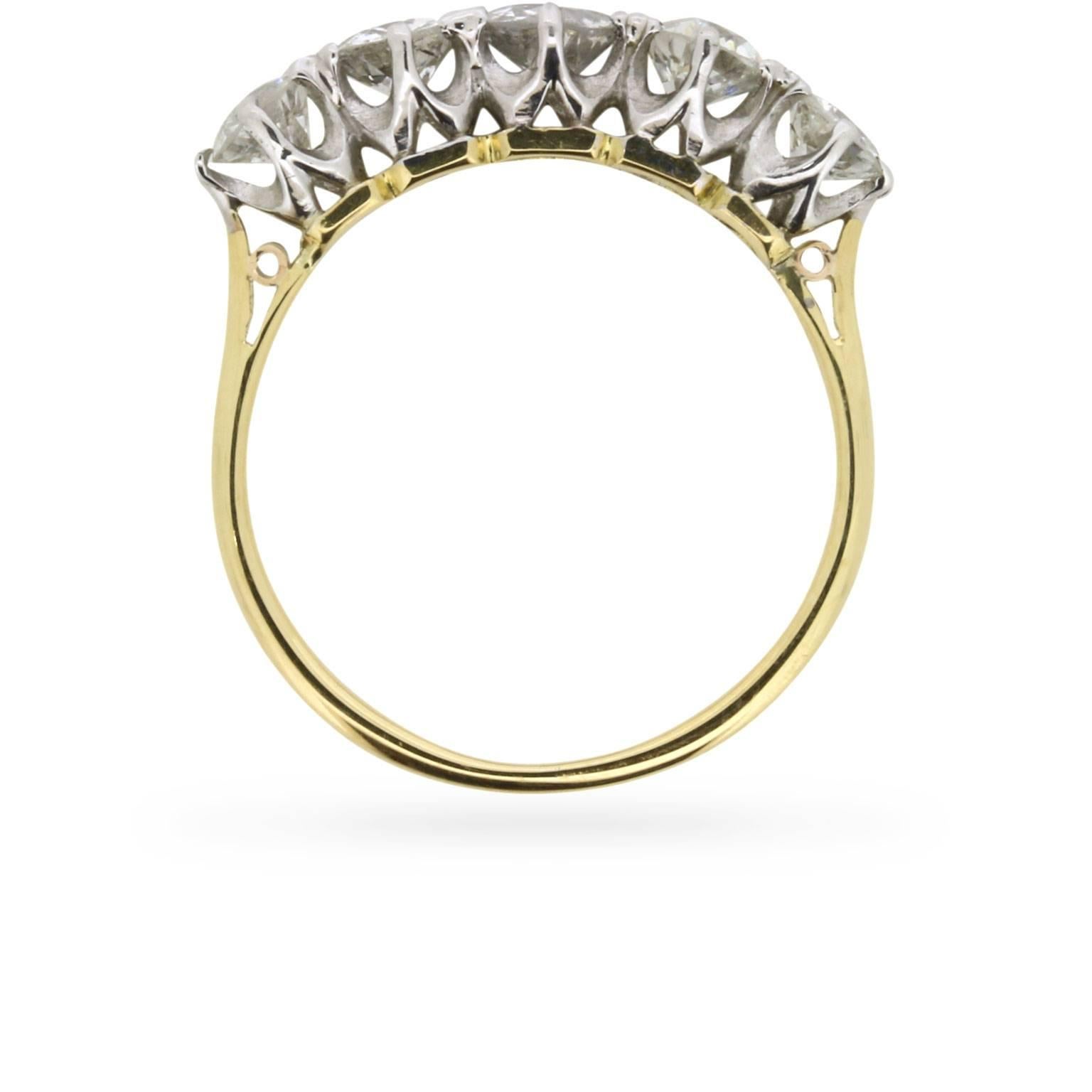 An old cut diamond, weighing 0.40 carat, is flanked by a pair of sister stones weighing 0.30 carat and 0.25 carat, creating a slightly graduated effect at the focal point of this antique diamond ring dating from the turn of the twentieth