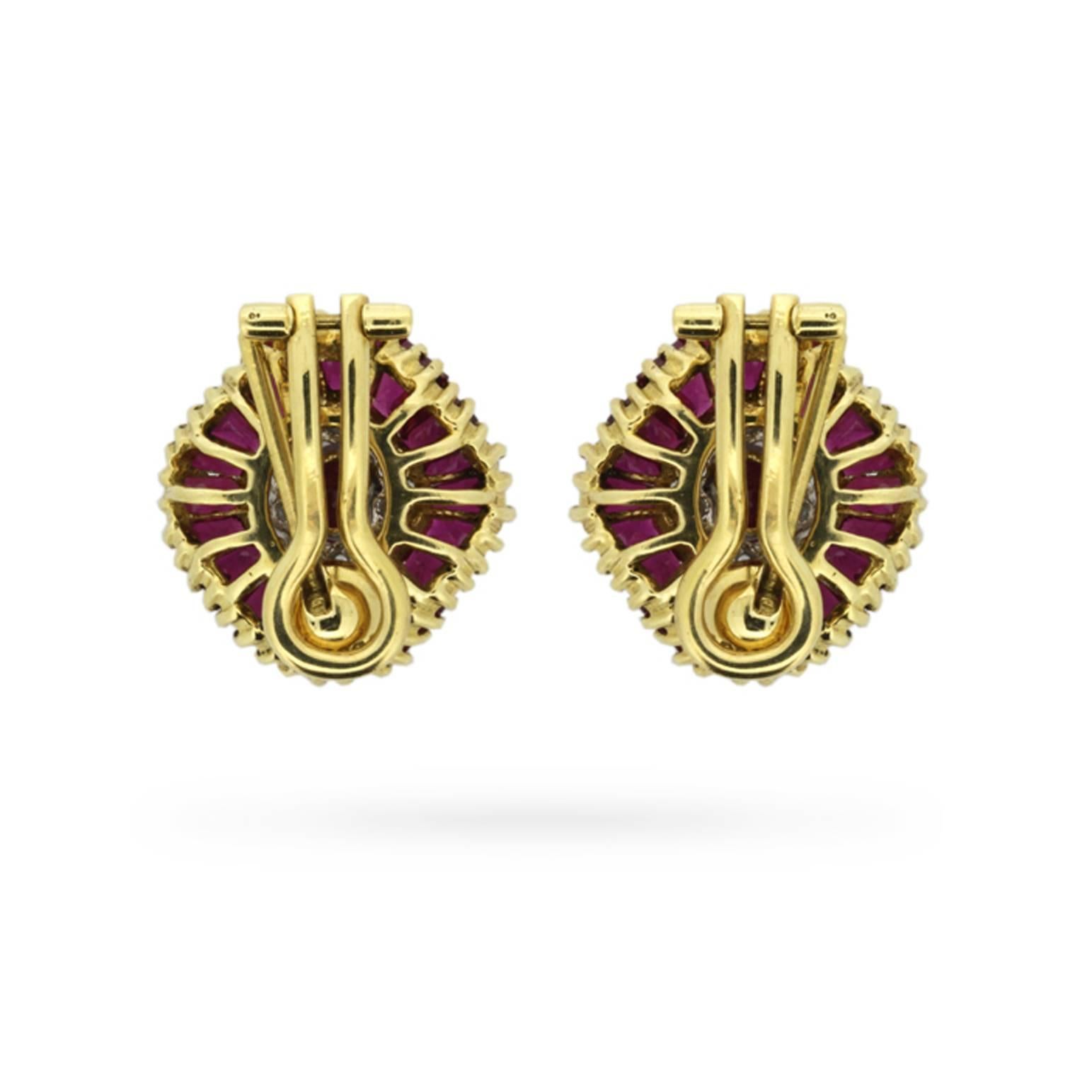 A sensational pair of 1970s ruby and diamond earrings boasting 4.00 carats of sumptuous rubies! These dramatic disco era earrings centre one vertically set oval-shaped ruby inside a concentric row of round brilliant cut diamonds, and a second row of