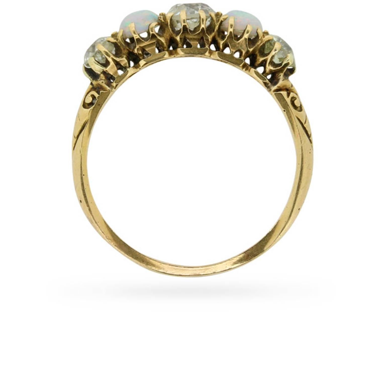 This five stone ring dating from the 1910s centres an old cut diamond between a magical pair of cabochon cut opals. One further old cut diamond set at each shoulder completes this beautiful quintet of antique stones.

The ring’s original, handmade,