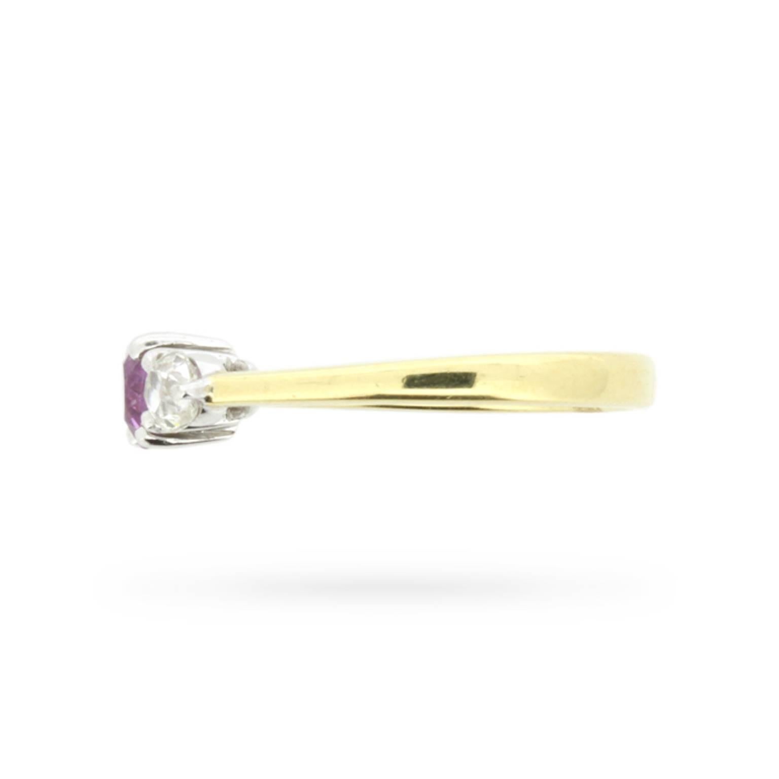 Twin, claw set, old cut diamonds sparkle to either side of a stunning pink sapphire set in 18 carat white gold at the centre of this unusual 1960s take on the timeless three stone engagement ring.

Tapered 18 carat yellow gold shoulders flow to a