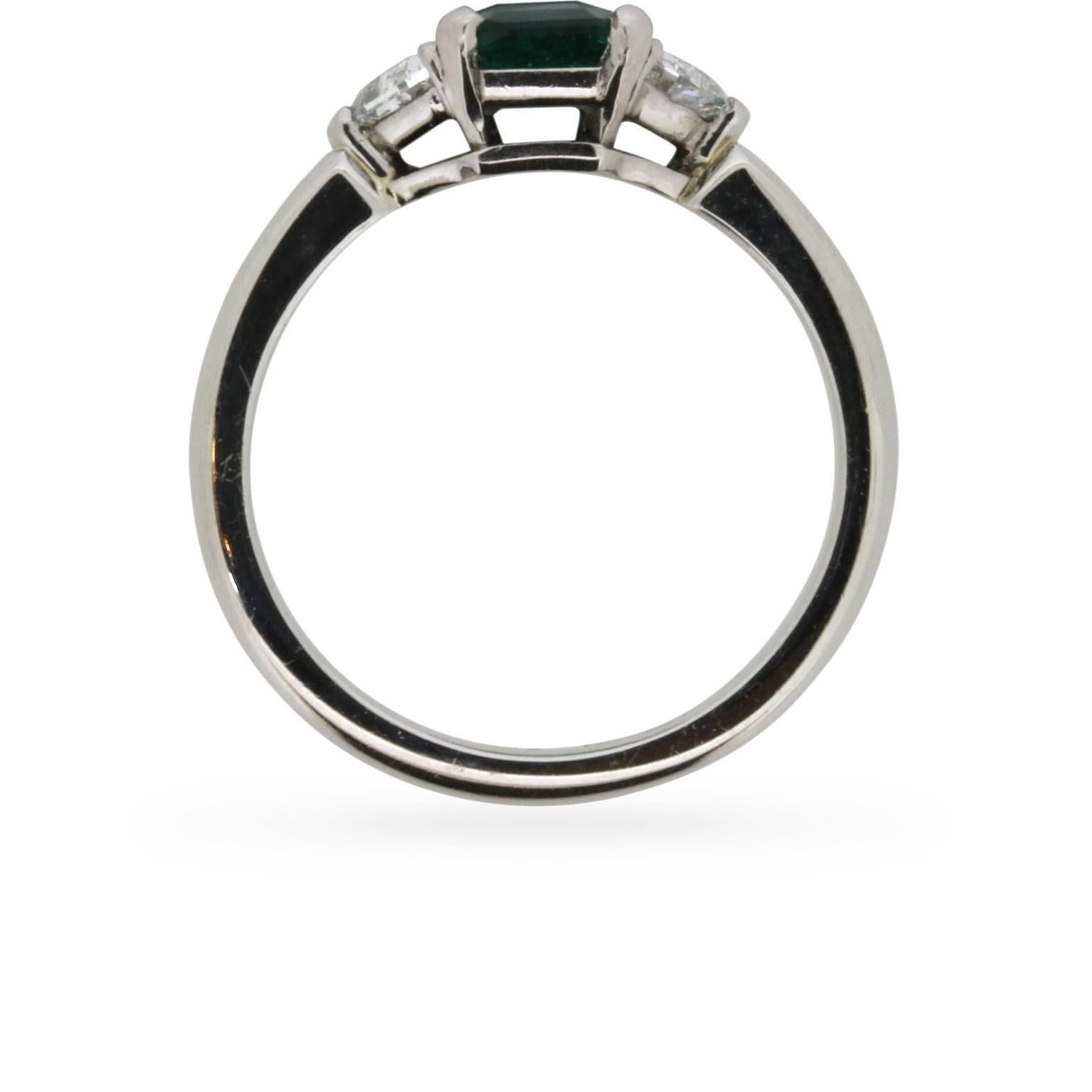 A lovely piece which highlights a stunning 0.70 carat Emerald with two shield diamonds either side, totalling 0.70 carats. This vintage ring has a clean and modern feel to the platinum band and claw settings for the stones.

Its near symmetry and