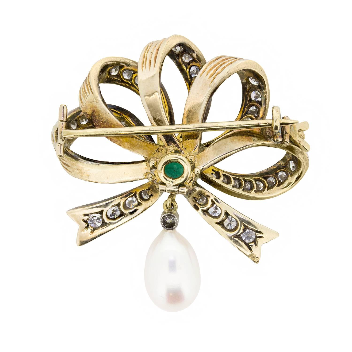 This stunning and vintage brooch is an elegant gift for any lady. The expertly designed bow is grain set with sparkling transitional cut diamonds. They have a combined total weight of 1.60 carats, and at the centre of the bow is a deep green