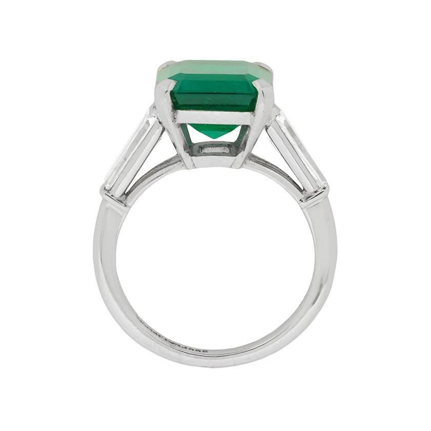 This truly stunning Emerald ring is one of a kind. The centre stone weighs 4.49 carat is a luscious deep green, supported by sparkling baguette cuts on the shoulders. The Emerald is a simply wonderful stone, originating from Colombian and graded as