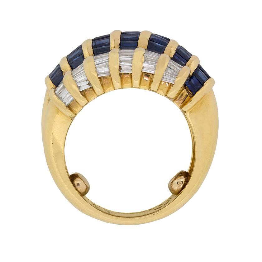 This statement ring features wonderfully set baguette cut sapphires and diamonds. The main stones are the sapphires, which are a deep, rich blue. They have a combined weight of 1.05 carat and are tension set in the centre. Parallel on either side