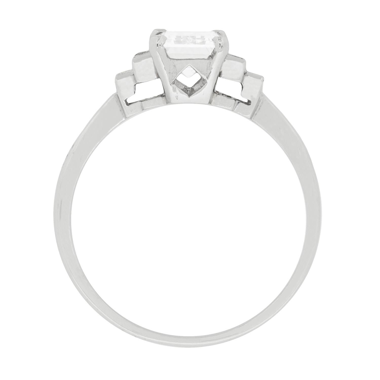 This geometric and stunning engagement ring dates to the 1940s, and features a centre Emerald cut diamond weighing 1.02 carat. It has been certified by world-wide certification company HRD as a F in colour and VS1 in clarity. It is perfectly set