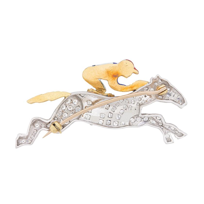 Beautifully made, this brooch of a horse and jockey mid-jump is studded with round brilliant diamonds. They make up the horse and have a combined weight of 2.10 carat. Estimated to be F to G in colour and VS in clarity, they sparkle in the 18 carat