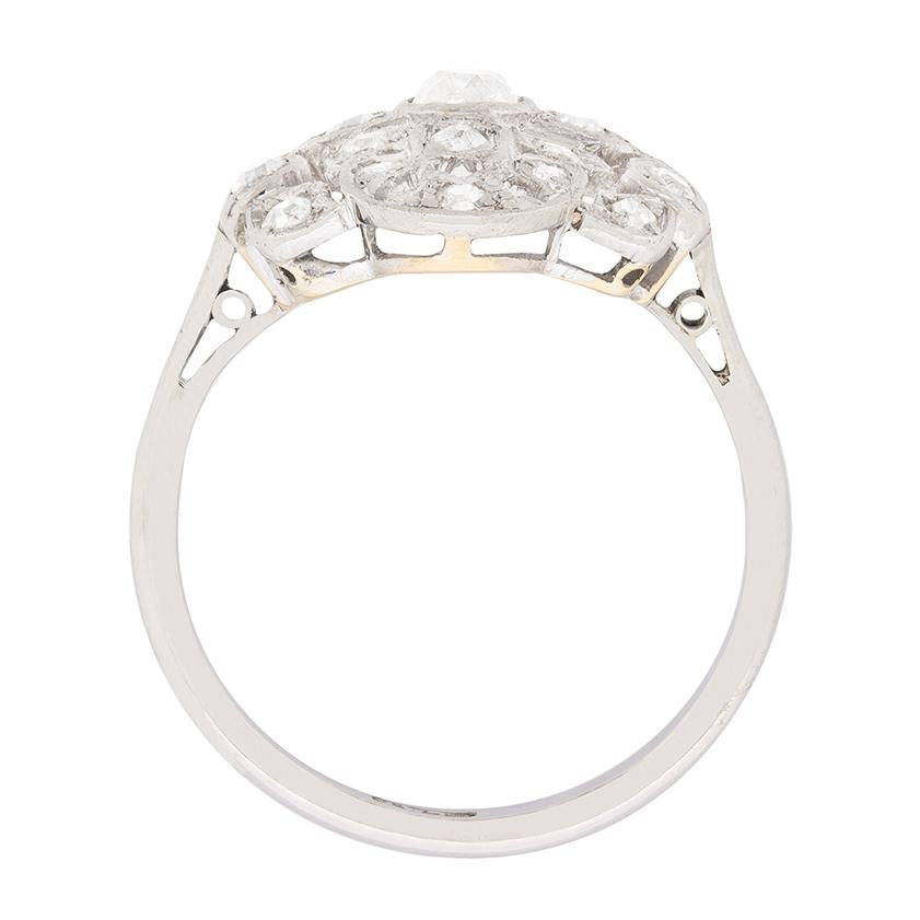 Dieser aufwendig gestaltete Ring hat ein Gesamtgewicht von 0,95 Karat und die Diamanten sind alle im alten Schliff. In der Mitte befindet sich ein 0,25-karätiger Diamant, der Rest des Gewichts entfällt auf das Clusterdesign mit körnig gefassten