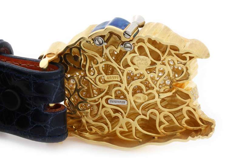 Henry Dunay belt buckle in 18K yellow gold. Buckle incorporates diamond pave, blue enamel accent, as well as larger round, marquise and pear shaped diamonds. Includes a blue shiny ladies alligator belt. Total diamond weight: 21.21ct. U.S. Retail