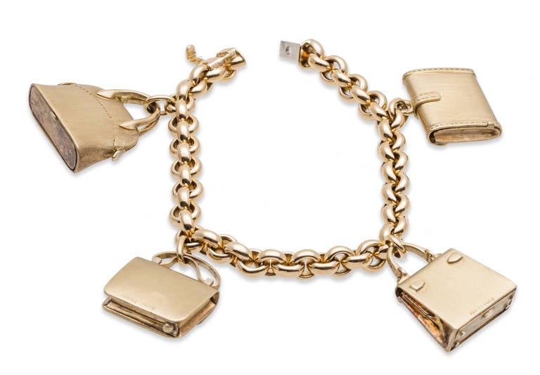Hermes hanging bag charm bracelet in 18K gold. Bracelet and (4) Charms, all signed Hermes Paris. Each bag opens to reveal a tiny secret compartment.