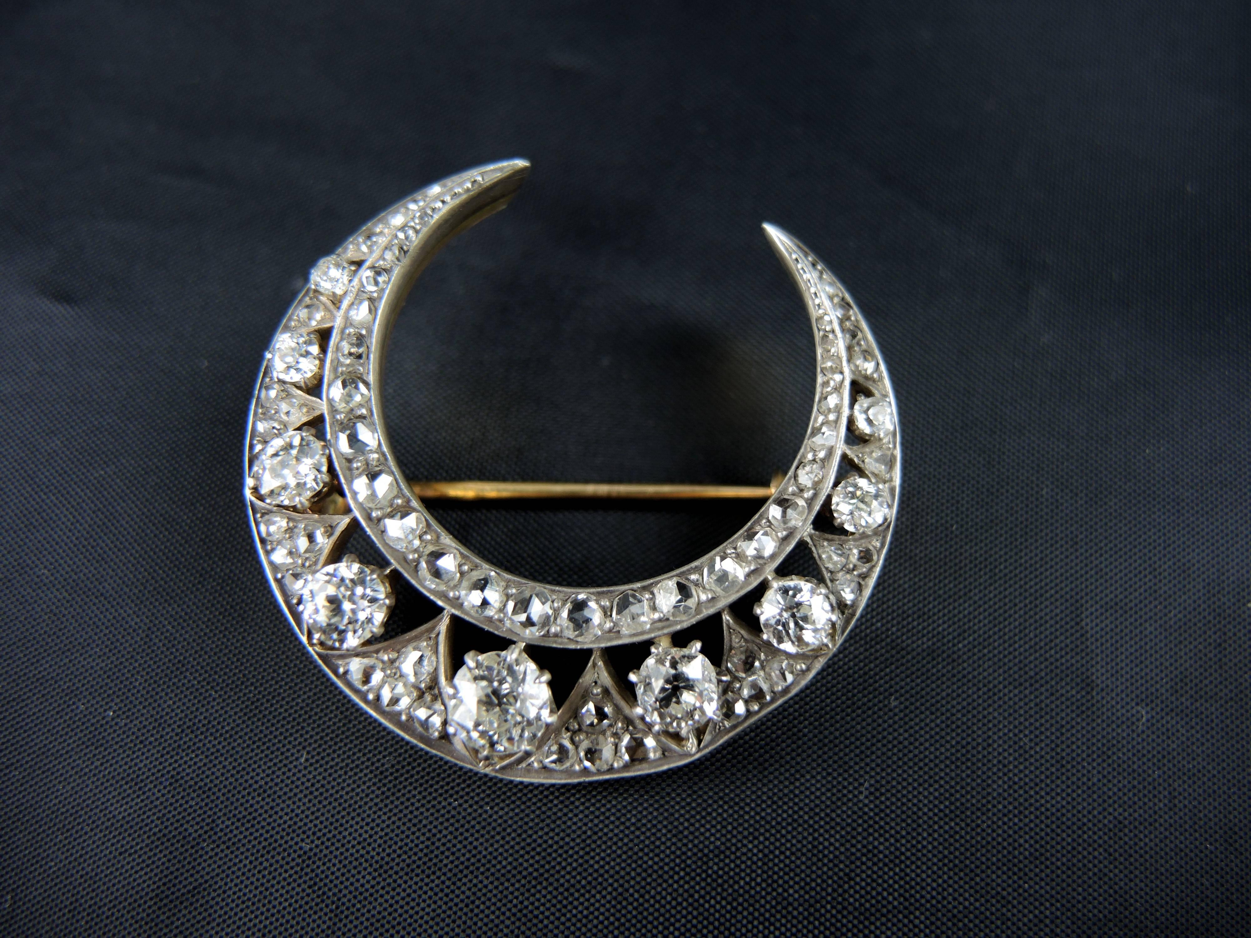 A stunning diamond crescent moon pin from the Napoleon III era (circa 1860) made of 18kt gold and silver (925/000). 
French quality marks: eagle and boar.

The silver is set with 9 sparkling old cut diamonds (apx 2,60 cts in total) and 56 rose