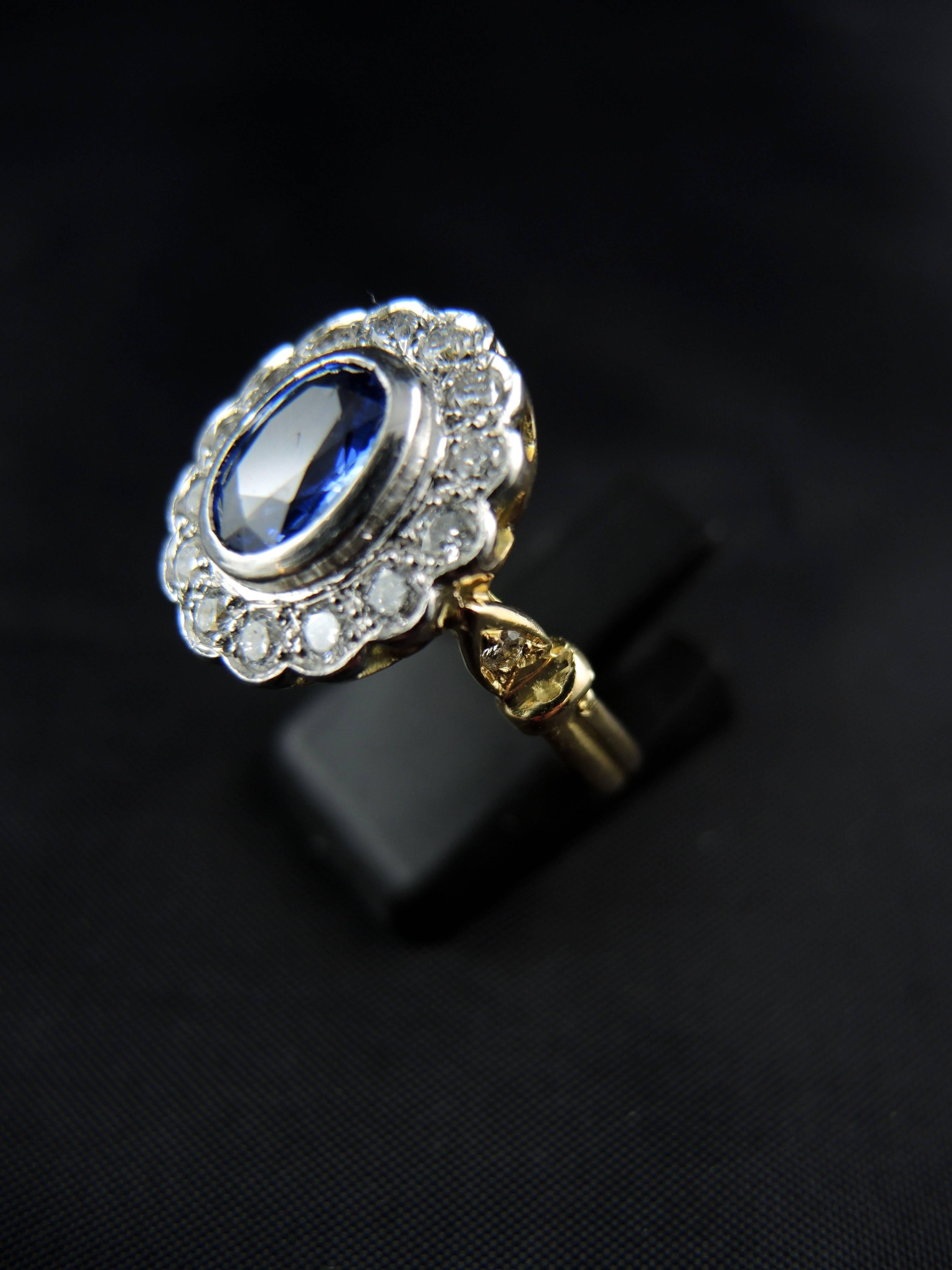 Yellow gold and platinium cluster ring (quality mark: head of dog and eagle) with a central oval sapphire, weight estimated  around 1,35 Ct, surrounded with modern cut diamonds, which total weight is estimated around 1,00 Ct.

Modern French