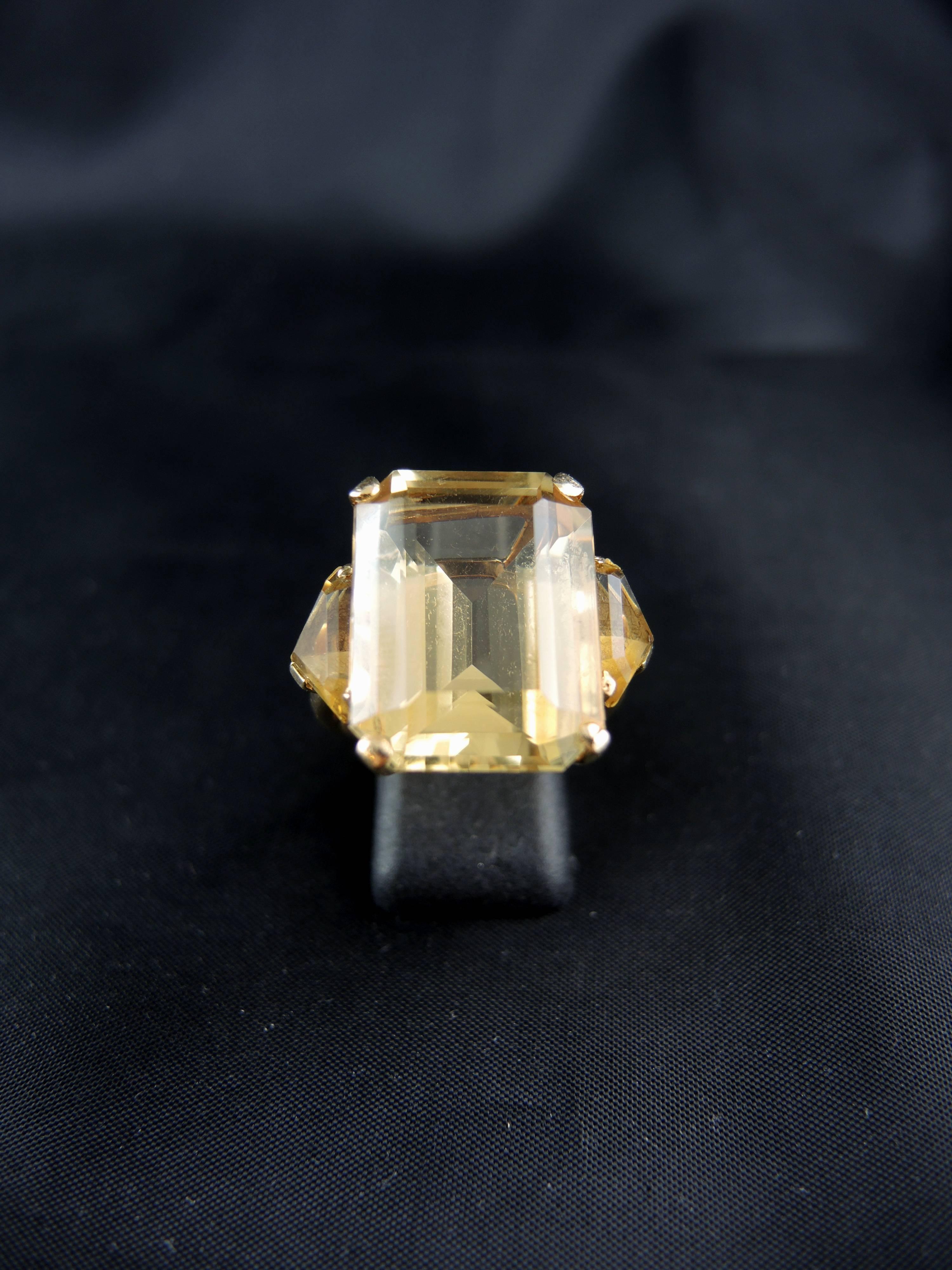14kt yellow gold ring (quality mark: scallop) set with a central emerald cut citrine, and triangular cut citrines (total weight of the citrines estimated around 20,00 Cts).

Work from the 70ies.

Weight: 11,10 g
Ring size: 58 (diameter 18,40/ US