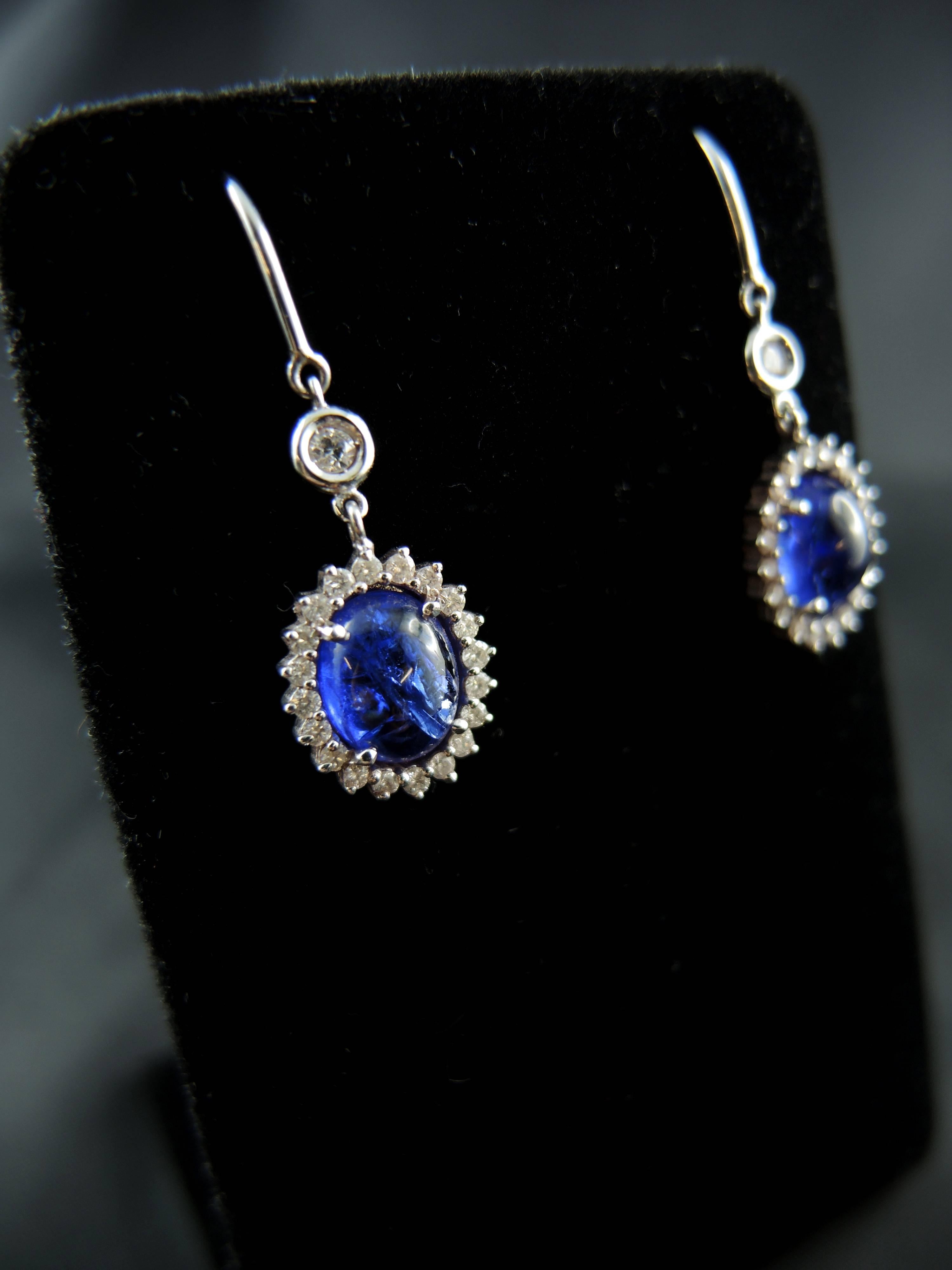 18kt white gold earrings (quality mark: eagle's head) set with stunning oval tanzanites' cabochon (total weight apx 5.45 Cts), surrounded by brillant modern cut diamonds (total weight apx 0.65 Ct).

French modern work.

Height: 3,50 cm

Weight: 5,20