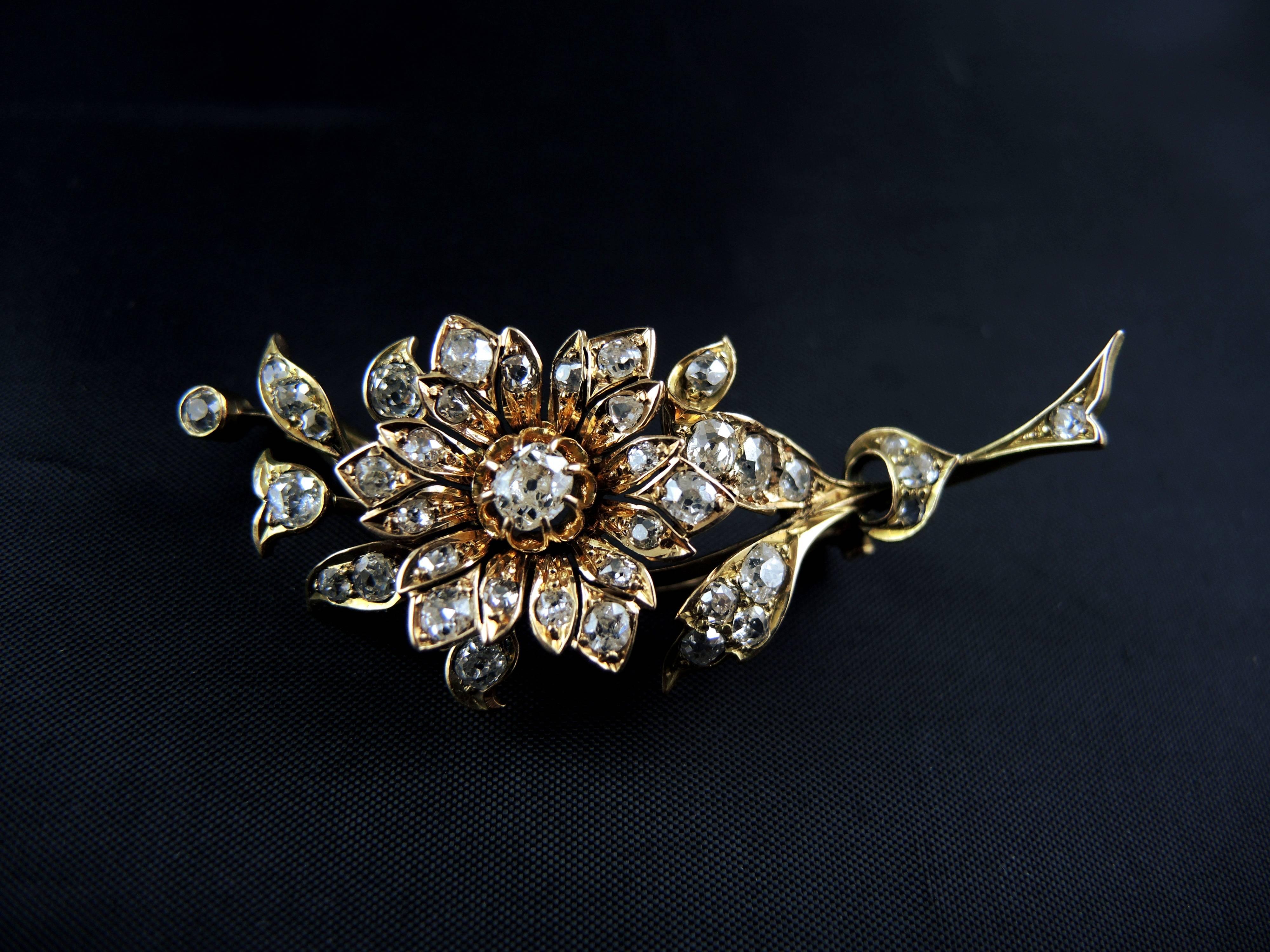 A stunning diamond flower brooch from the Napoleon III era (circa 1860) made of 14kt gold (hallmark: scallop).

The brooch is set with old and rose cut diamonds, which total weight is estimated around 2,40 Cts.

Lenght: 5,50 g
Weight: 10,90 g