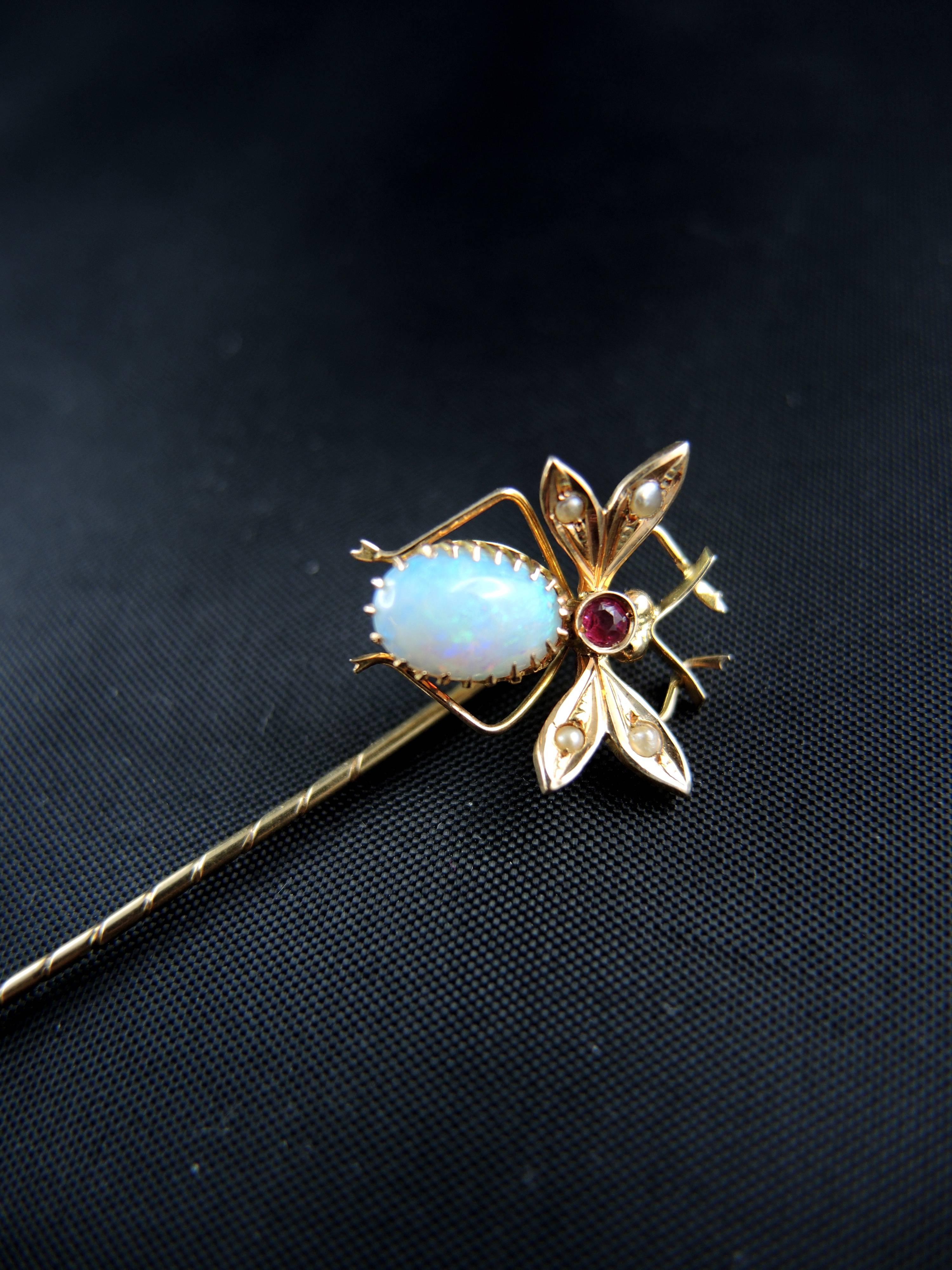 14kt yellow gold antique pin (quality mark: scallop) showing an insect who's body is set with an opal's cabochon, a red stone, and the wings with natural seed pearls. 

Work from the 19th century.

Weight: 1,50 g
Lenght: 6,50 cm

State : very little