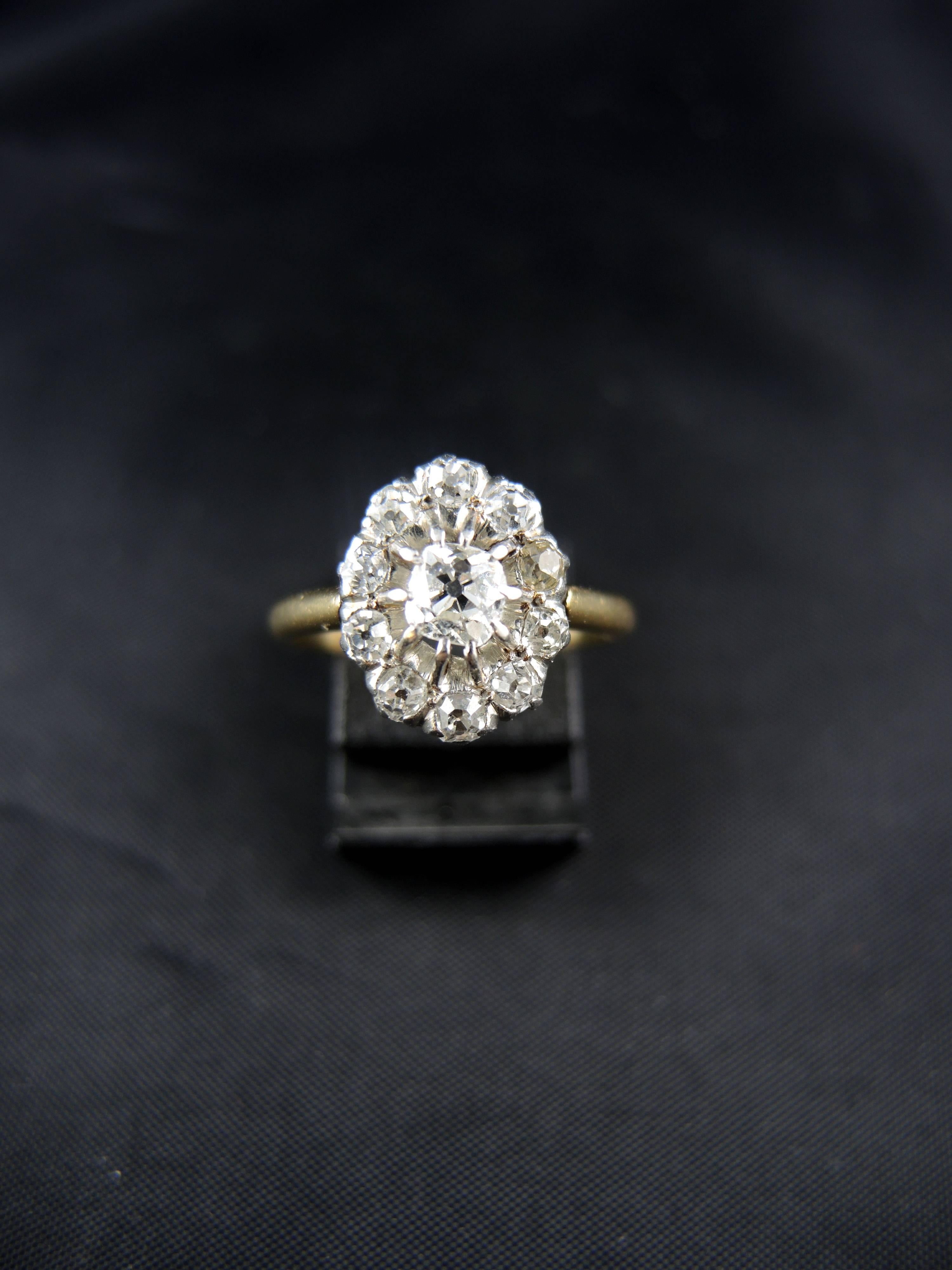 18kt gold and platinium engagment ring (hallmarks: owl and Mascaron) set with old mine cut diamonds (total weight apx 1,20 Ct)

Circa 1900. 

Weight: 4,20g 
Ring size: 55 (diameter 17,50/ US size 7,25). 
Hight of the central pattern: 1,30 cm

State