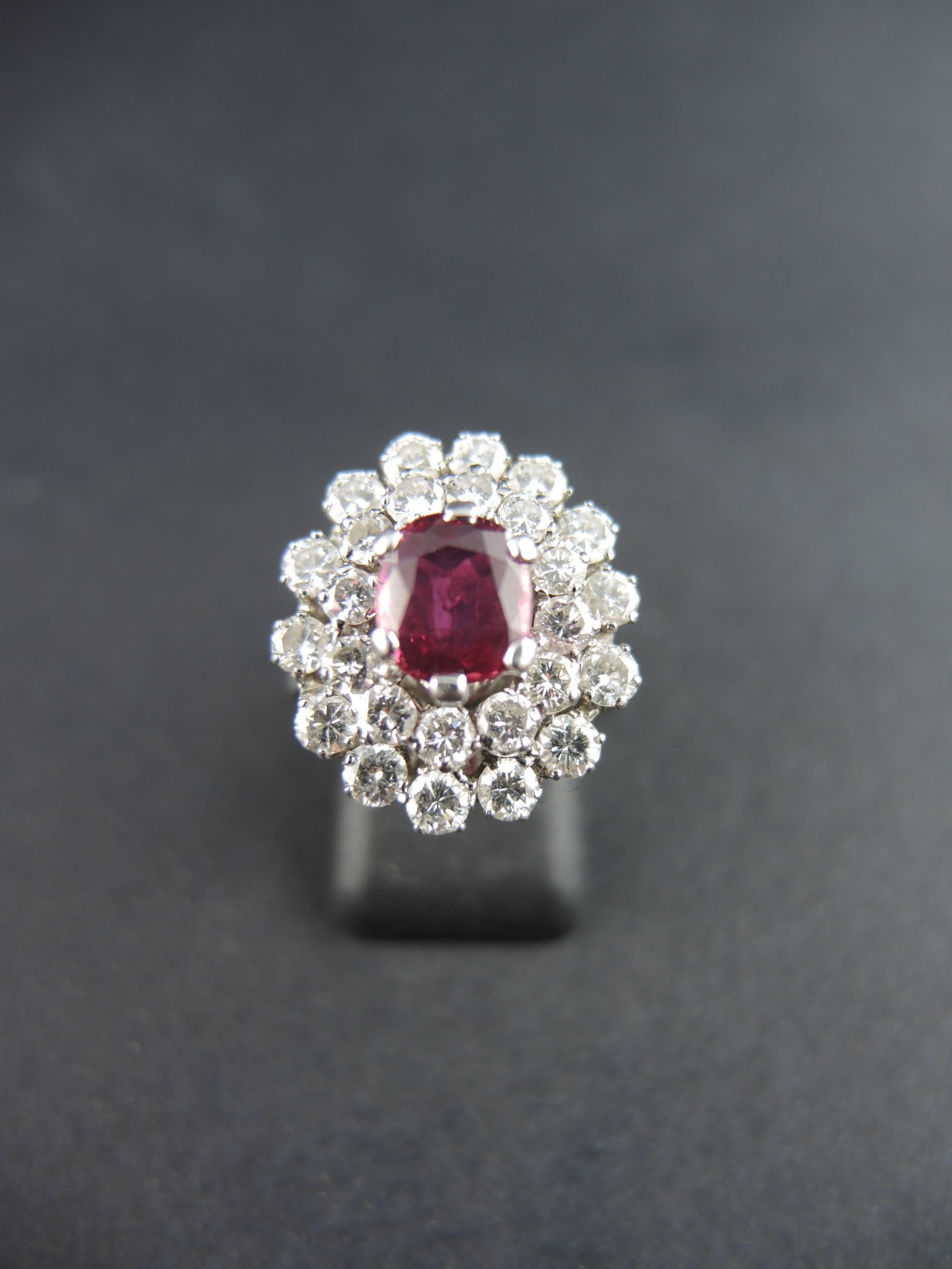 18kt white gold cluster ring (quality mark: owl) set with an oval ruby, weighting apx 1,00 ct, surrounded with two ranks of modern cut diamonds, total weight estimated around 2,10 cts.

Circa 1980.

Weight: 6,70g
Ring size: 51 (diameter 16,25 / US