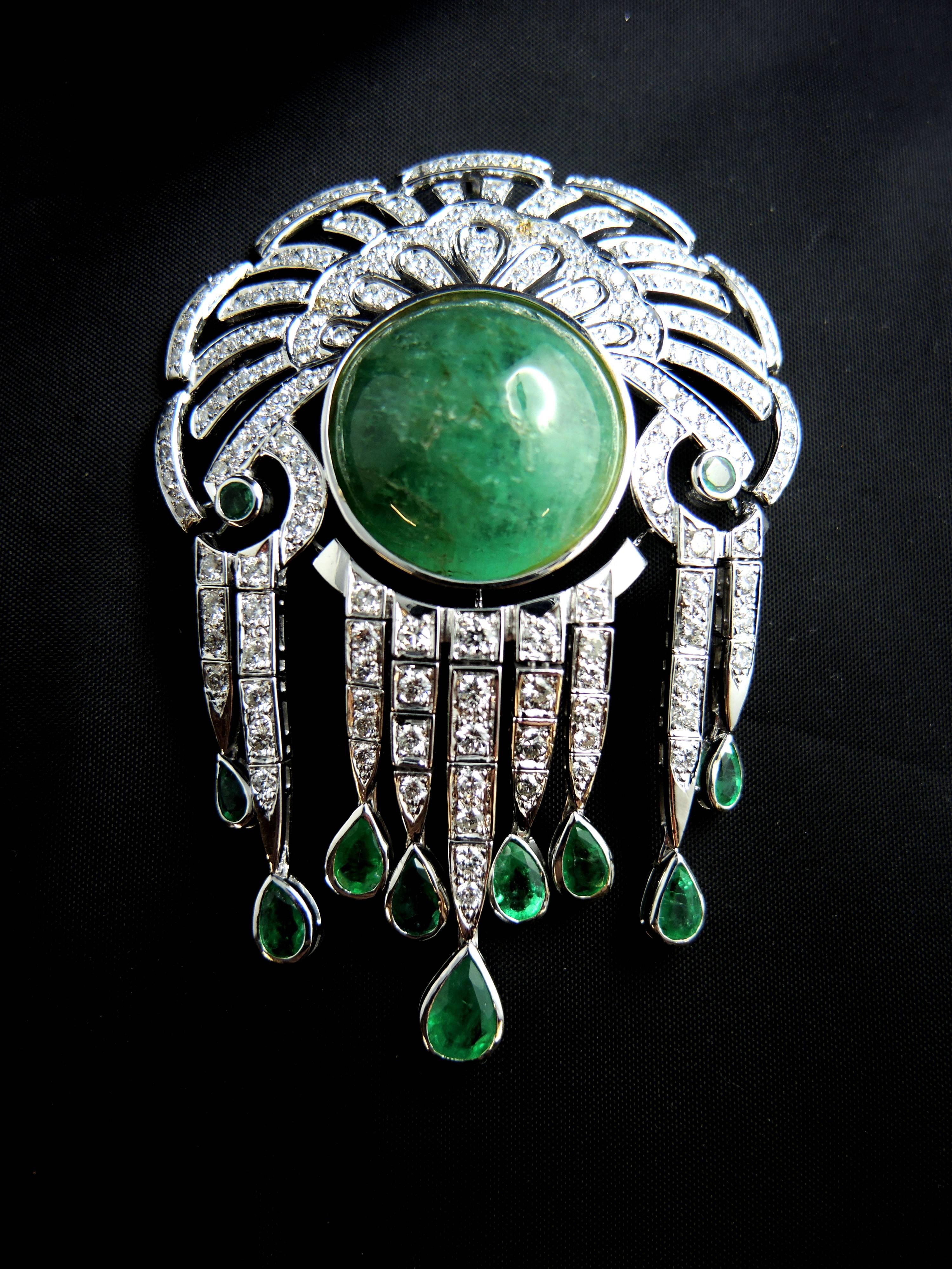 Brooch and pendant in 18 carat white gold, eagle head hallmark, set with a stunning central cabochon of emerald (apx 75.00 cts), pear shape and round emeralds (total weight: apx 3.00 cts), and brillant cut diamonds (total weight: apx 5.00 ct).

It