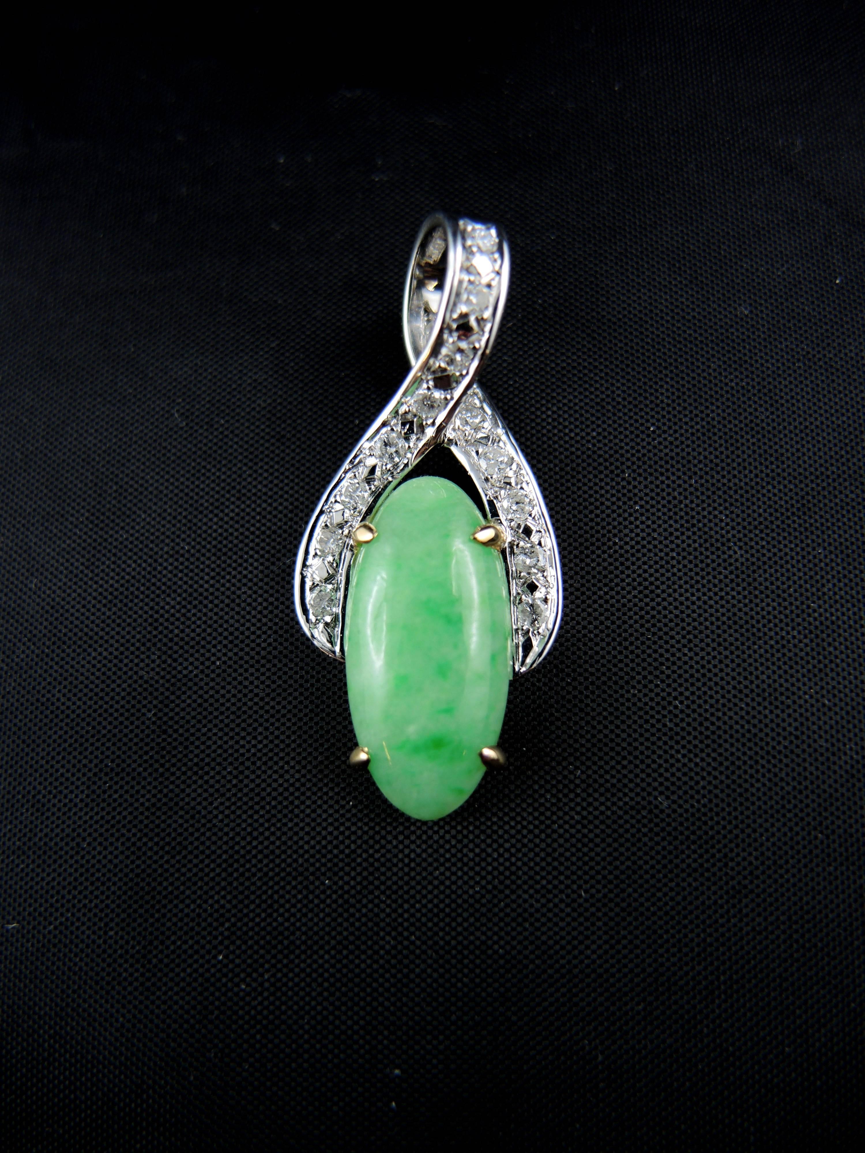 18 kt white and yellow gold pendant (quality mark: head of eagle), set with a stunning  oval cut jadeite jade, weight apx 5,00 Cts, surrounded with round brilliant cut diamonds (total weight apx 0,75 ct).