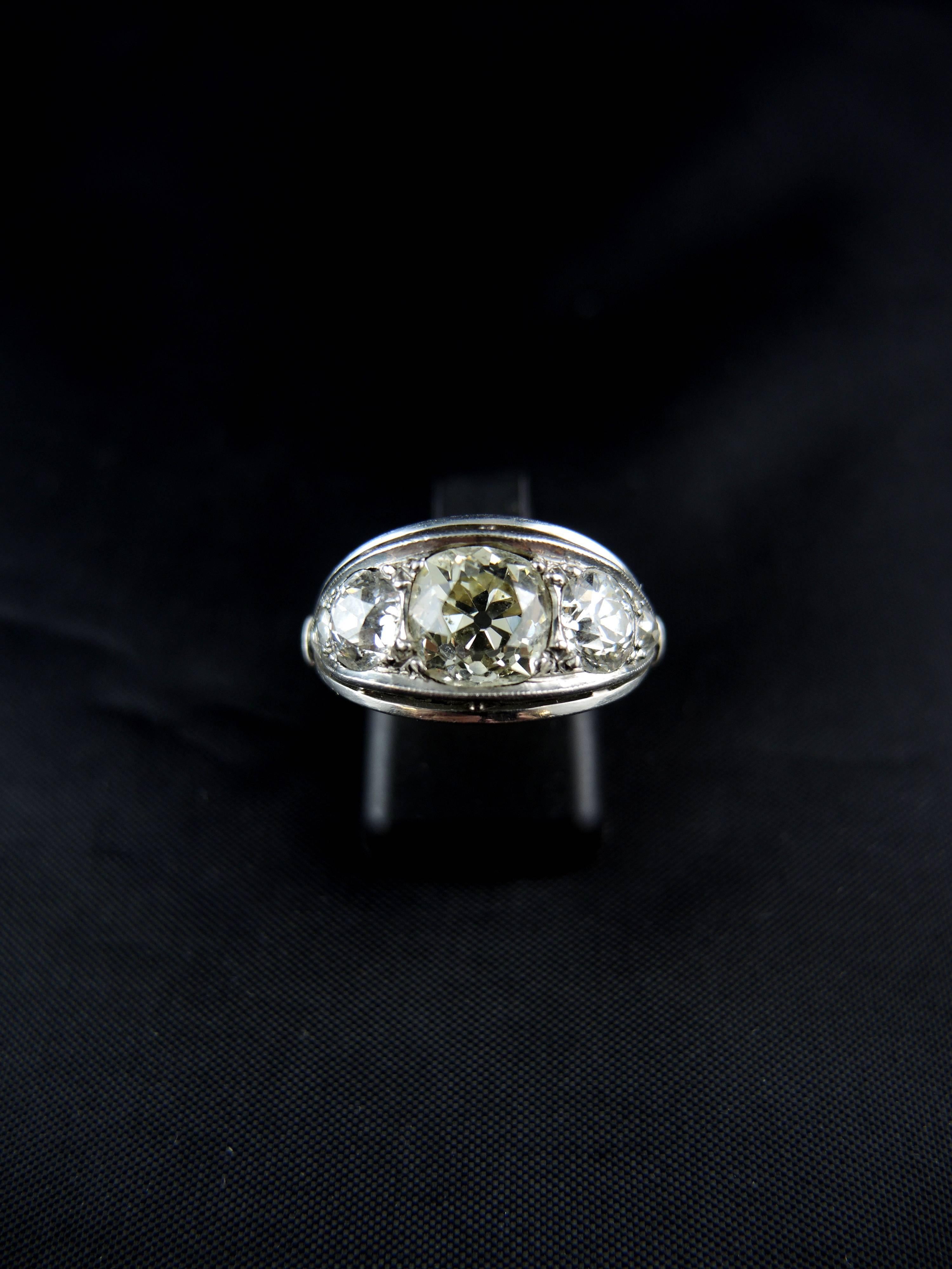 Stunning platinium engagment ring (quality mark: head of dog) set with a  central old cut diamond, weighting apx 1,70 Cts (color estimated M-Z/ Clarity estimated SI2), with two old cut diamonds, which total weight is estimated around 1,20 Ct (color