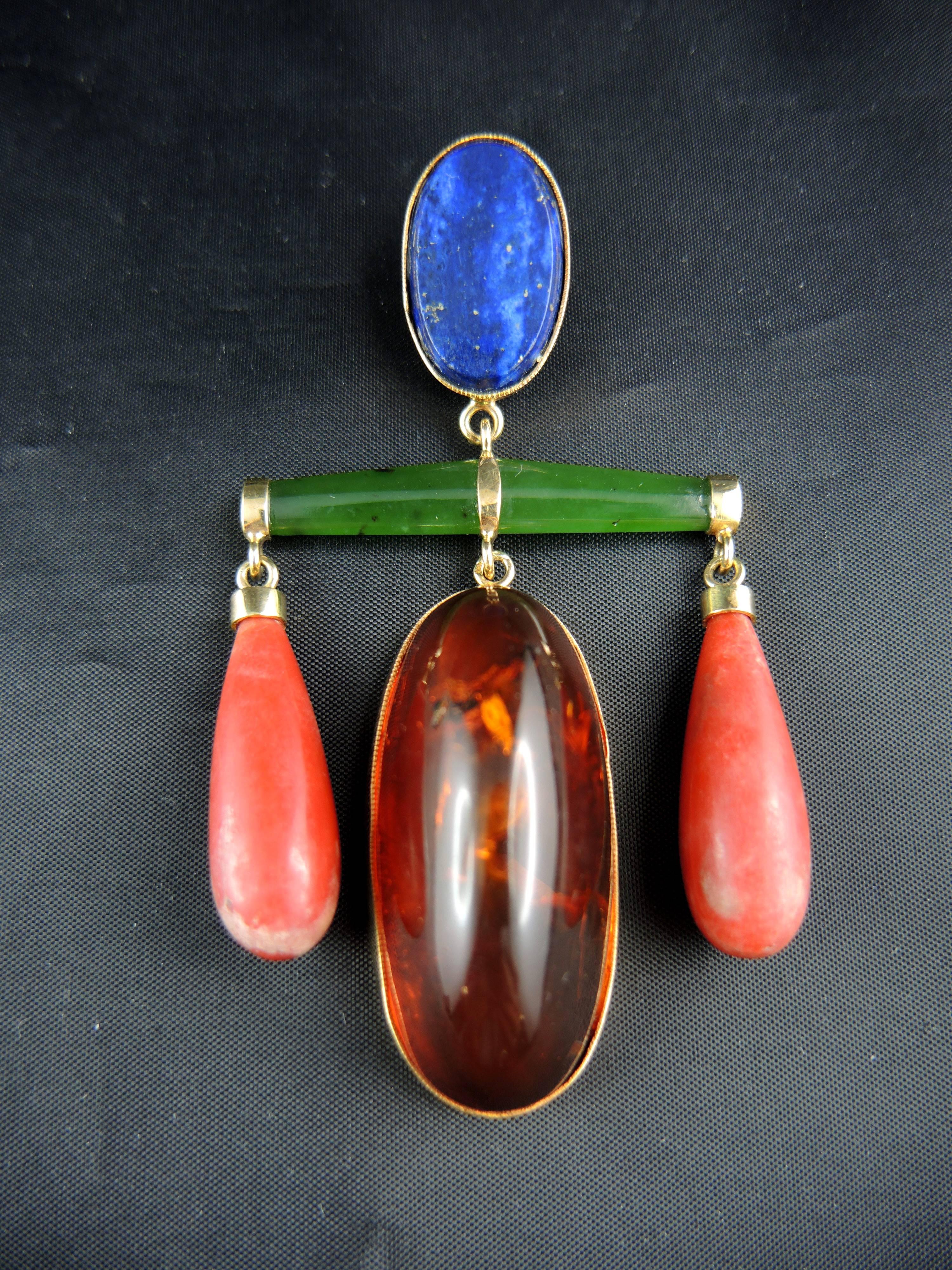 18 kt yellow gold pendant (quality mark: eagle's head), set a lapis lazuli, two coral drops, an amber cabochon, and jade.
Sold without the chain.

French Modernist work, circa 1960.

Weight:10.00g
Height: 8.00 cm