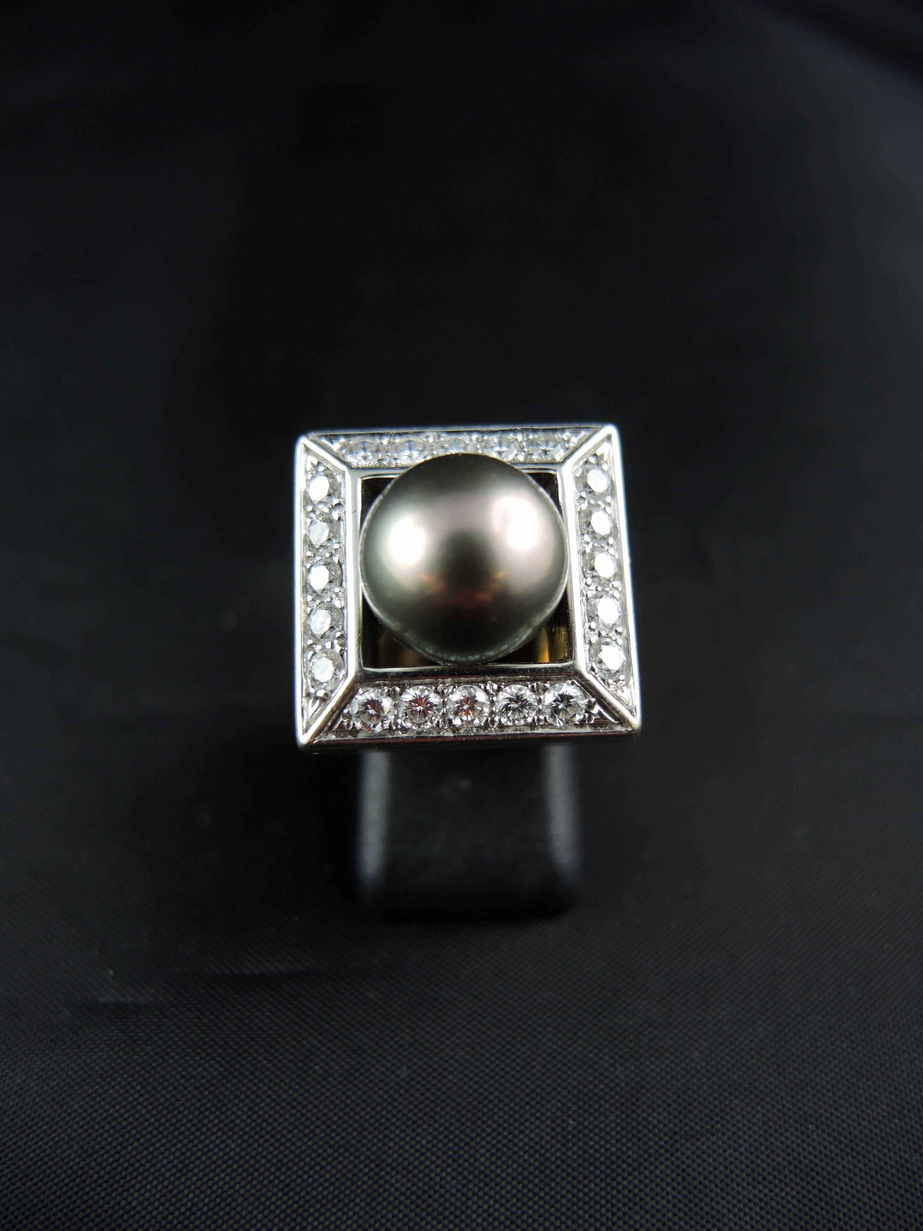 18 Kt white and yellow gold ring (quality mark: head of eagle) set with a central Tahitian black cultured pearl, surrounded by modern cut diamonds, total weight apx 1,00 Ct.

Beautiful modern french work.

Weight: 18,70g
Ring size: 52 (diameter