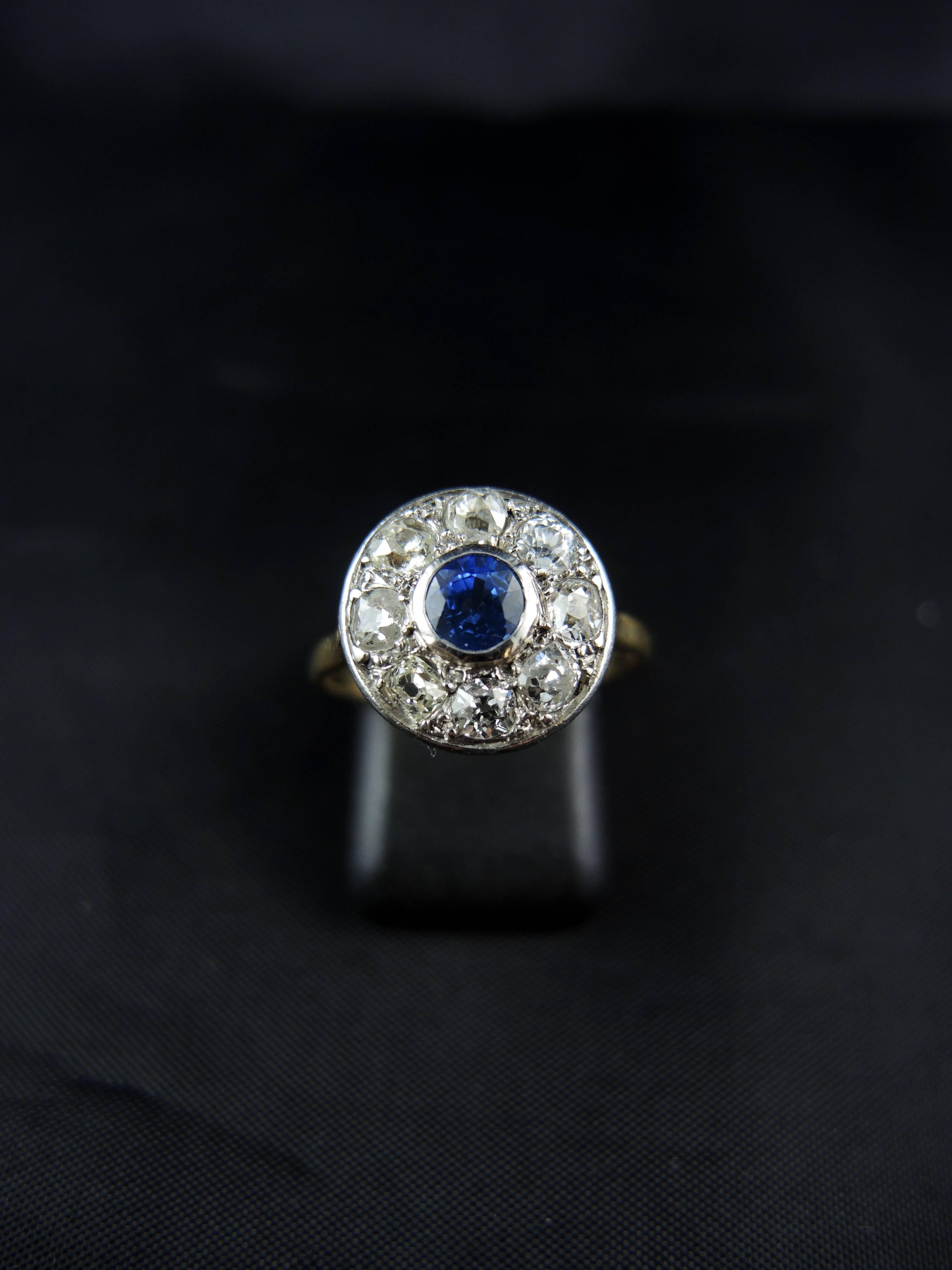 18kt gold and platinium cluster ring (quality mark: owl and mascaron) set with a central round sapphire, weighting apx 0.50 Ct, surrounded with old cut diamonds, total weight estimated around 1,00 Ct.

Circa 1920.

Weight: 3,60 g
Ring size: 55
