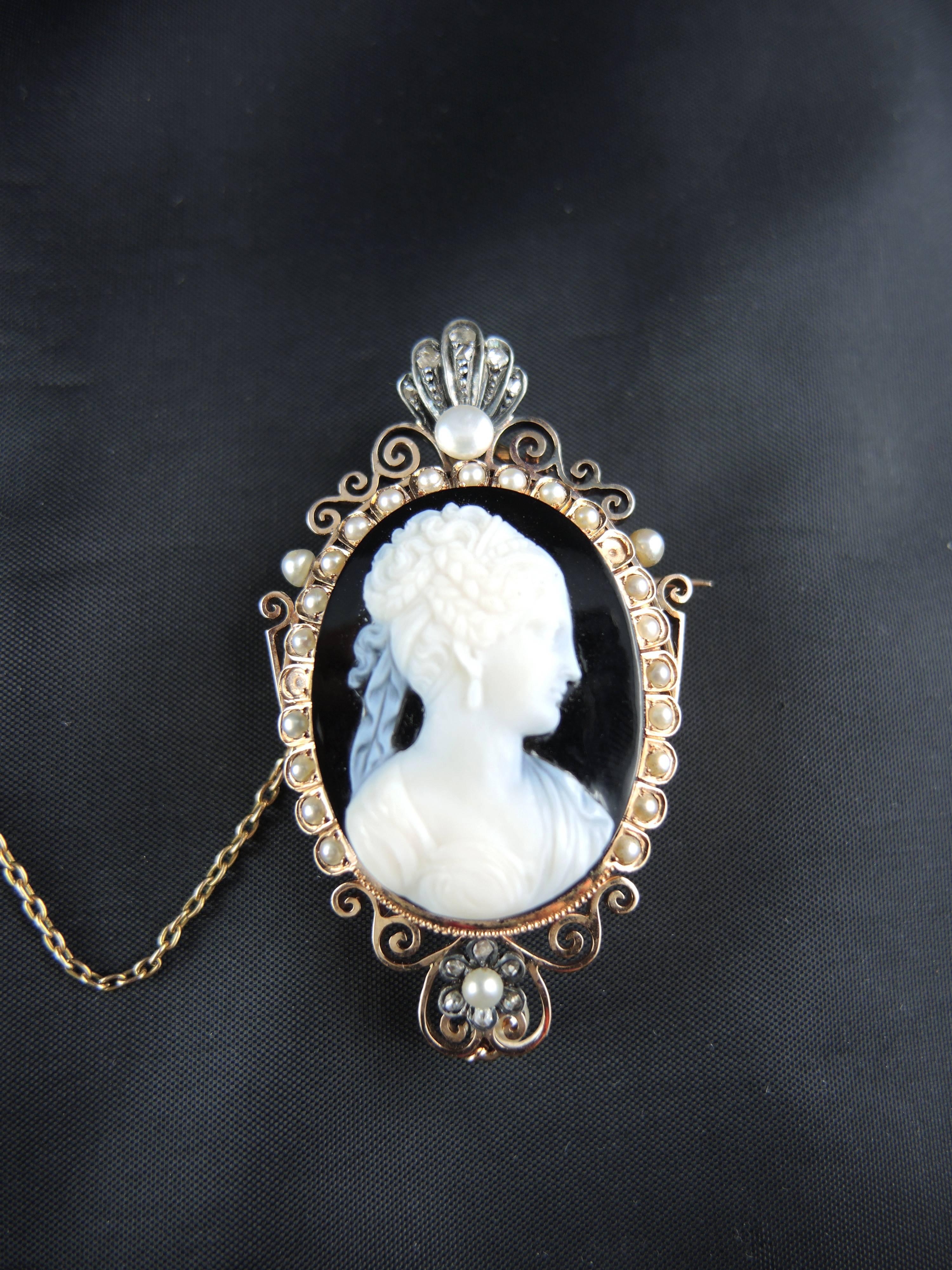 18kt rose gold brooch and pendant (quality mark: eagle's head) set with an agate cameo portraying a woman, surrounded with natural pearls and rose cut diamonds.

French work from the middle of the 19th century.

Weight: 21,90g
Height: 6,00 cm

State